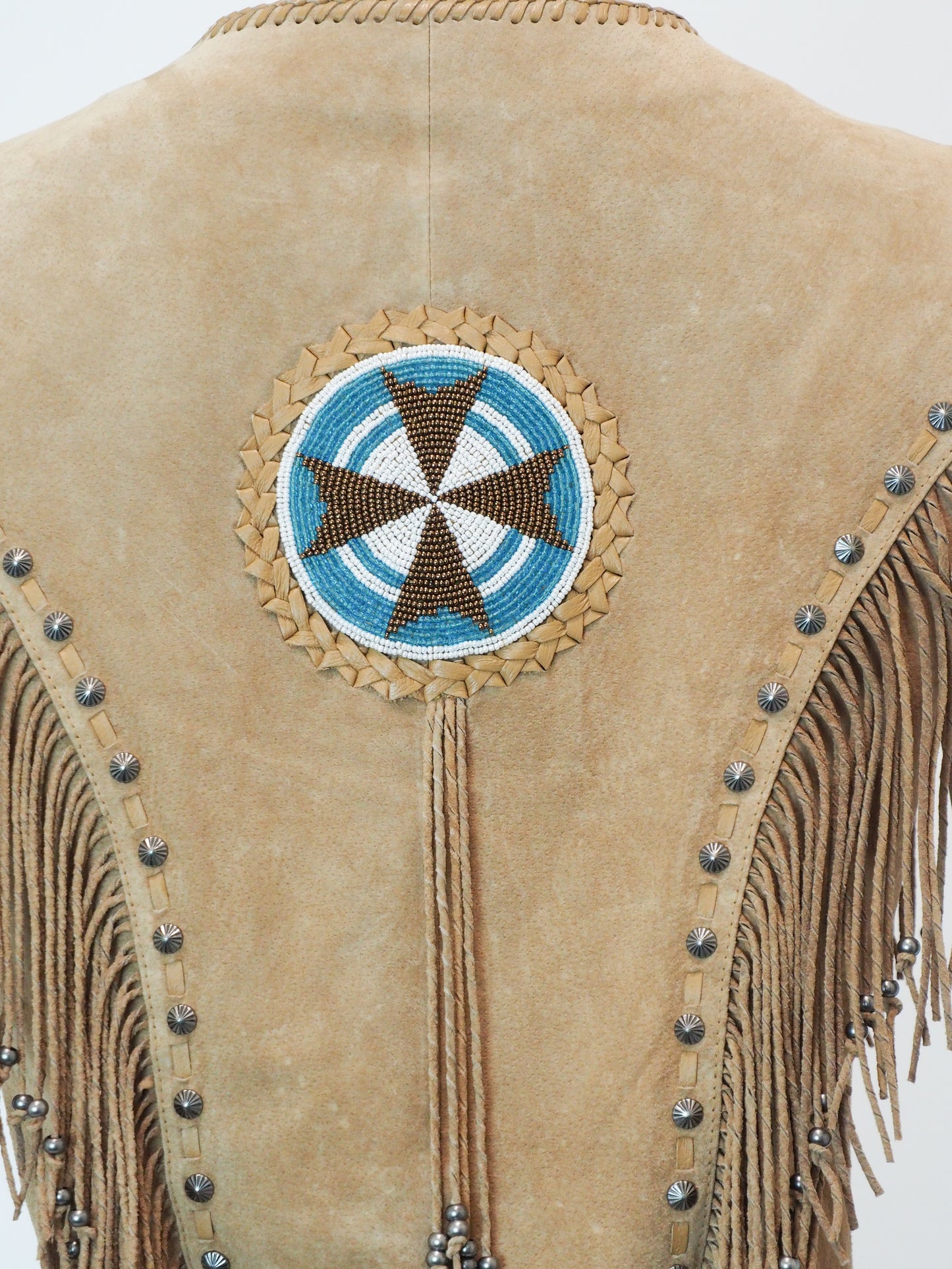 Beige leather jacket with decorative beadwork and fringes on a white background
