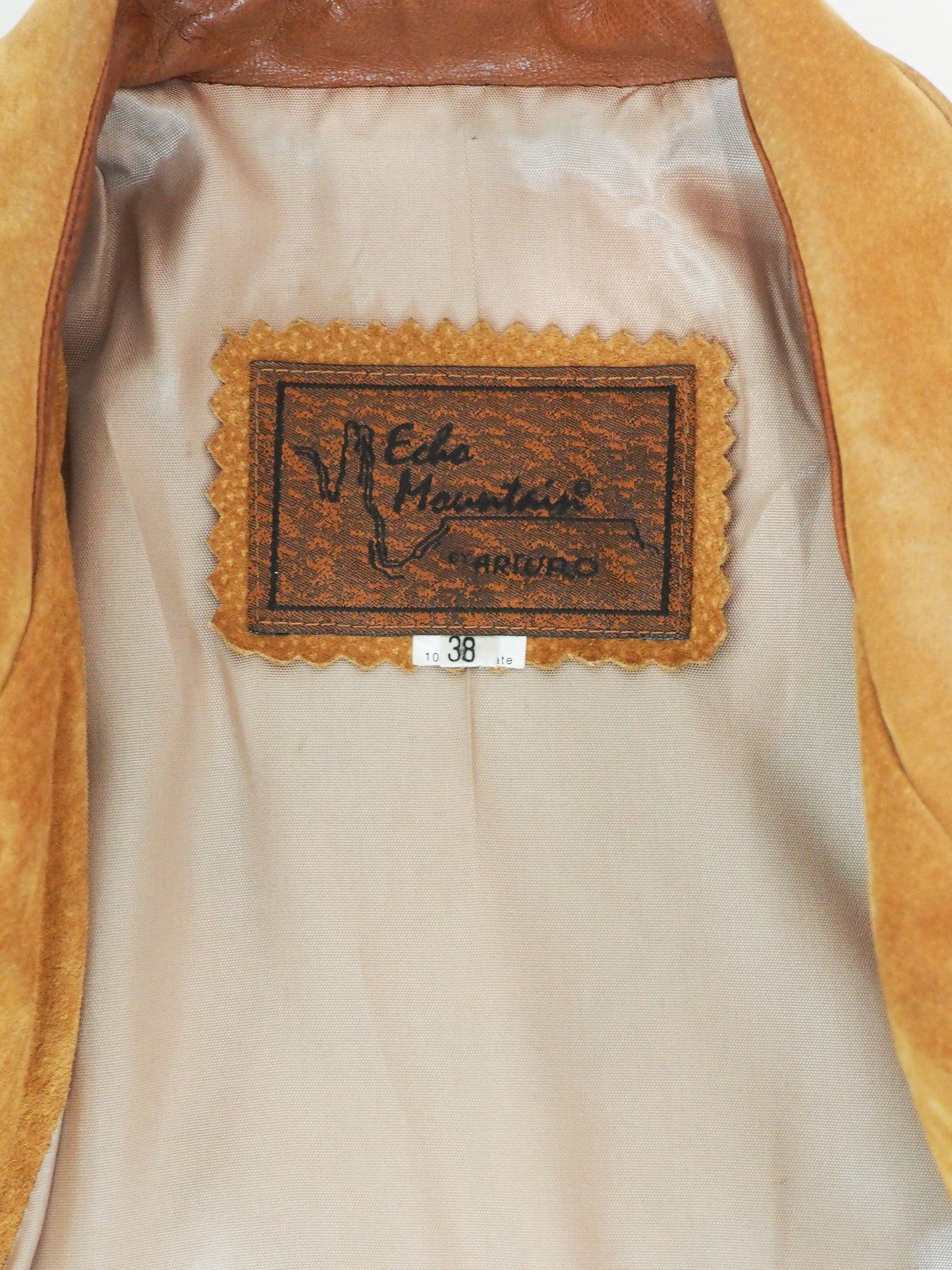 Close-up of a label on a brown leather jacket with 'Arturo' branding.
