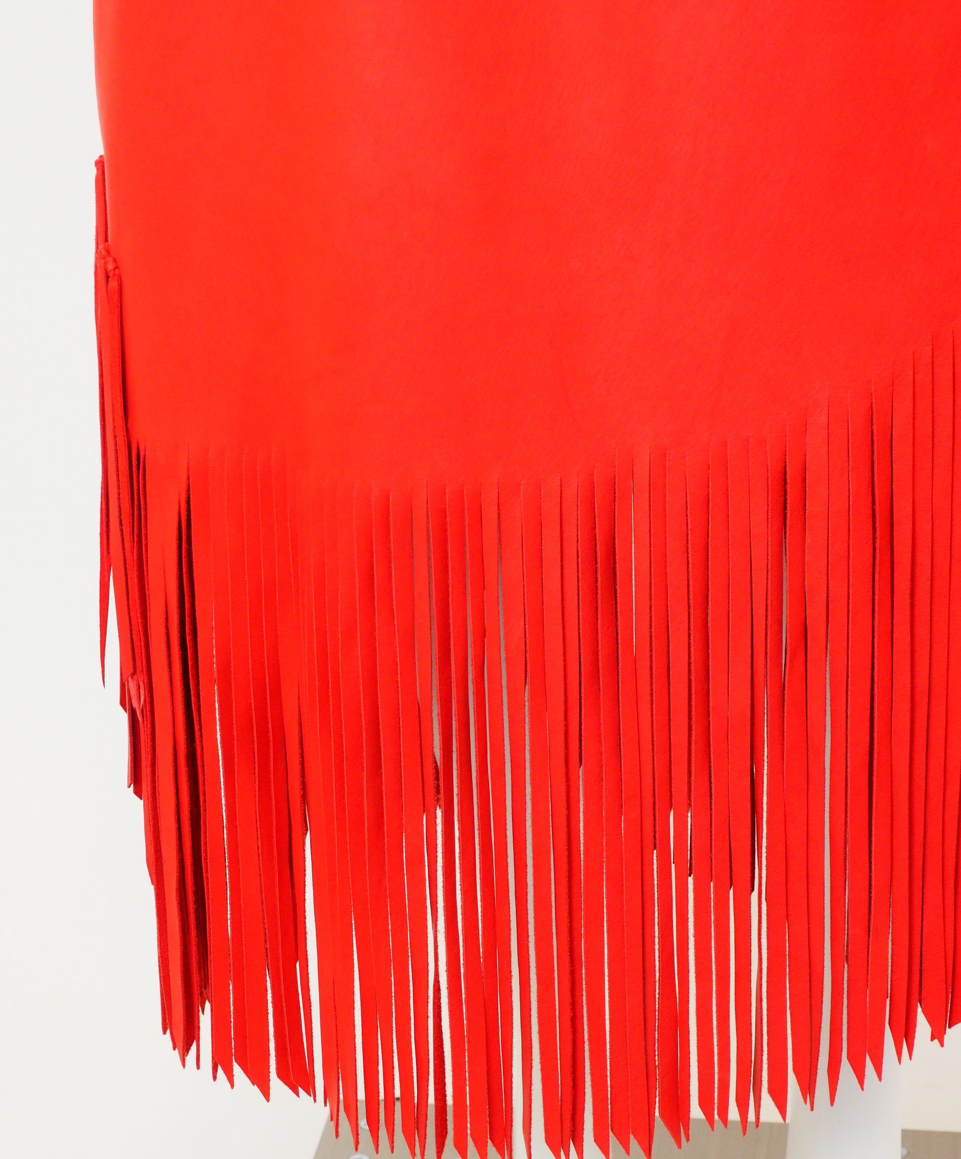 Close-up of a red fringe garment on a white background
