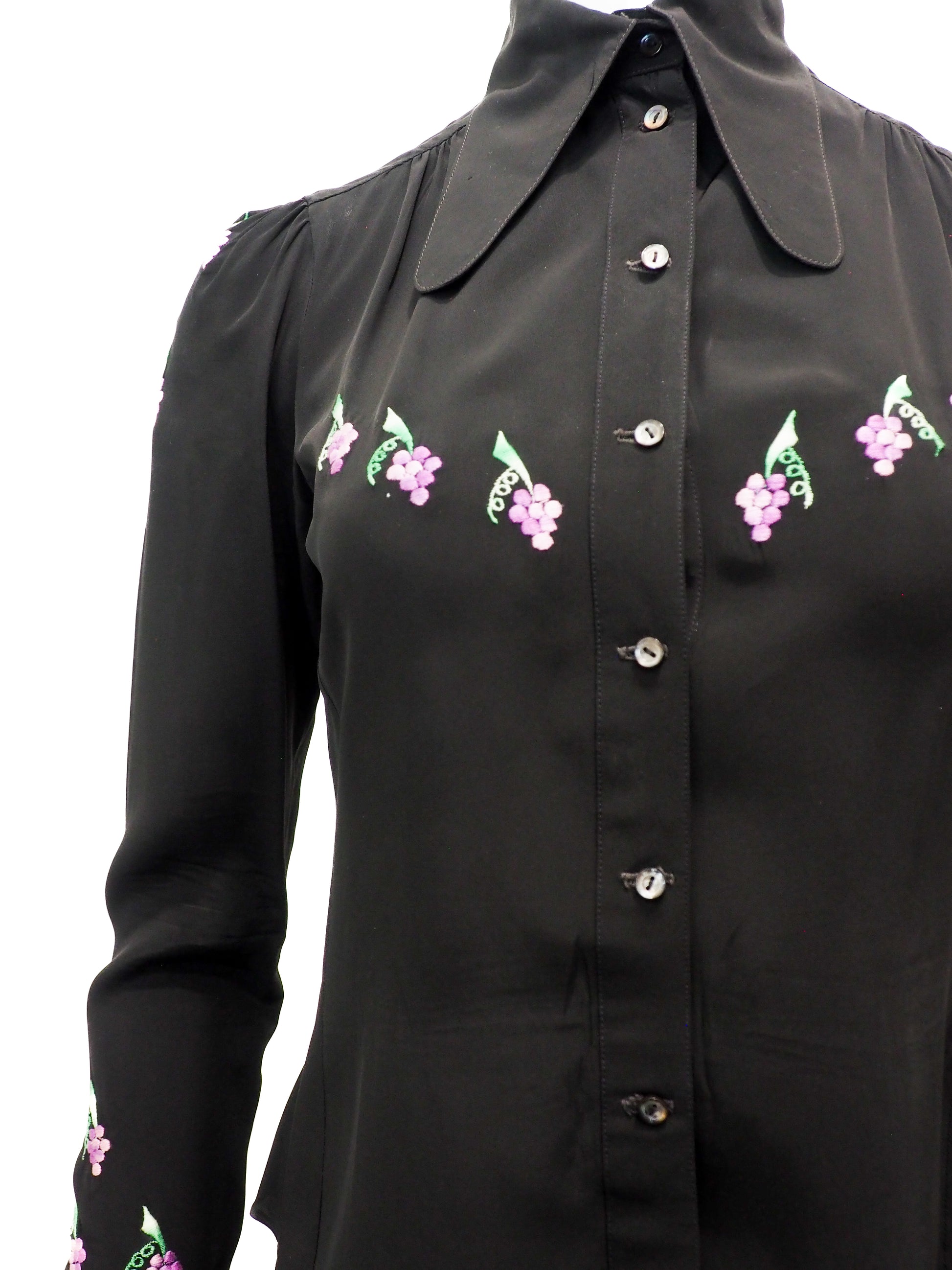 Black blouse with floral embroidery on a white background