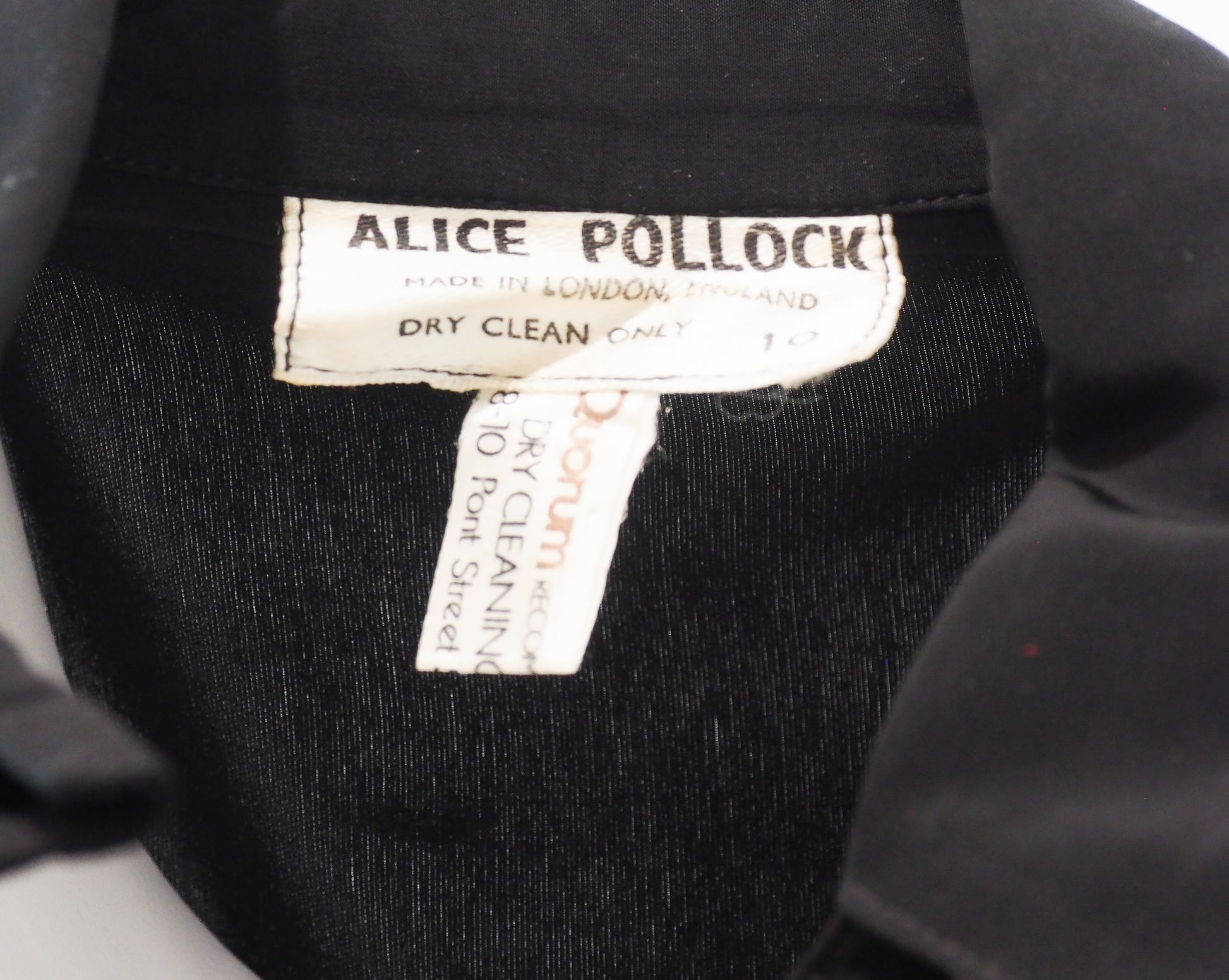Close-up of a black garment with an Alice Pollock label.