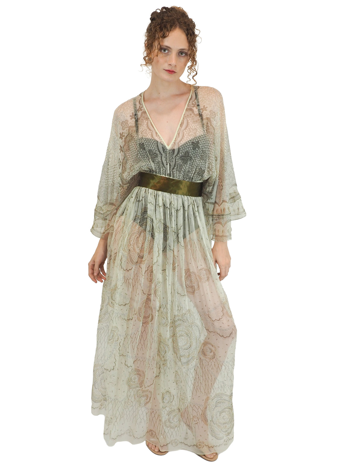 A vintage Zandra Rhodes long sheer maxi dress with a print detailing, wide three-quarter sleeves, and a wide dark olive green belt at the waist