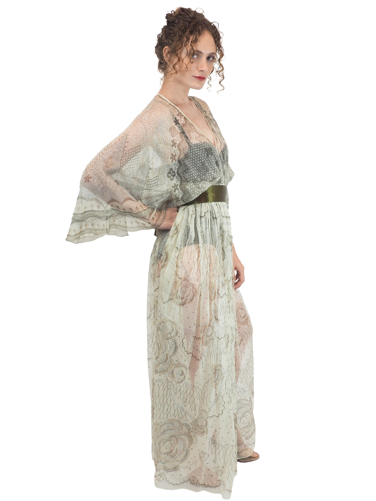 A vintage Zandra Rhodes long sheer maxi dress with a print detailing, wide three-quarter sleeves, and a wide dark olive green belt at the waist