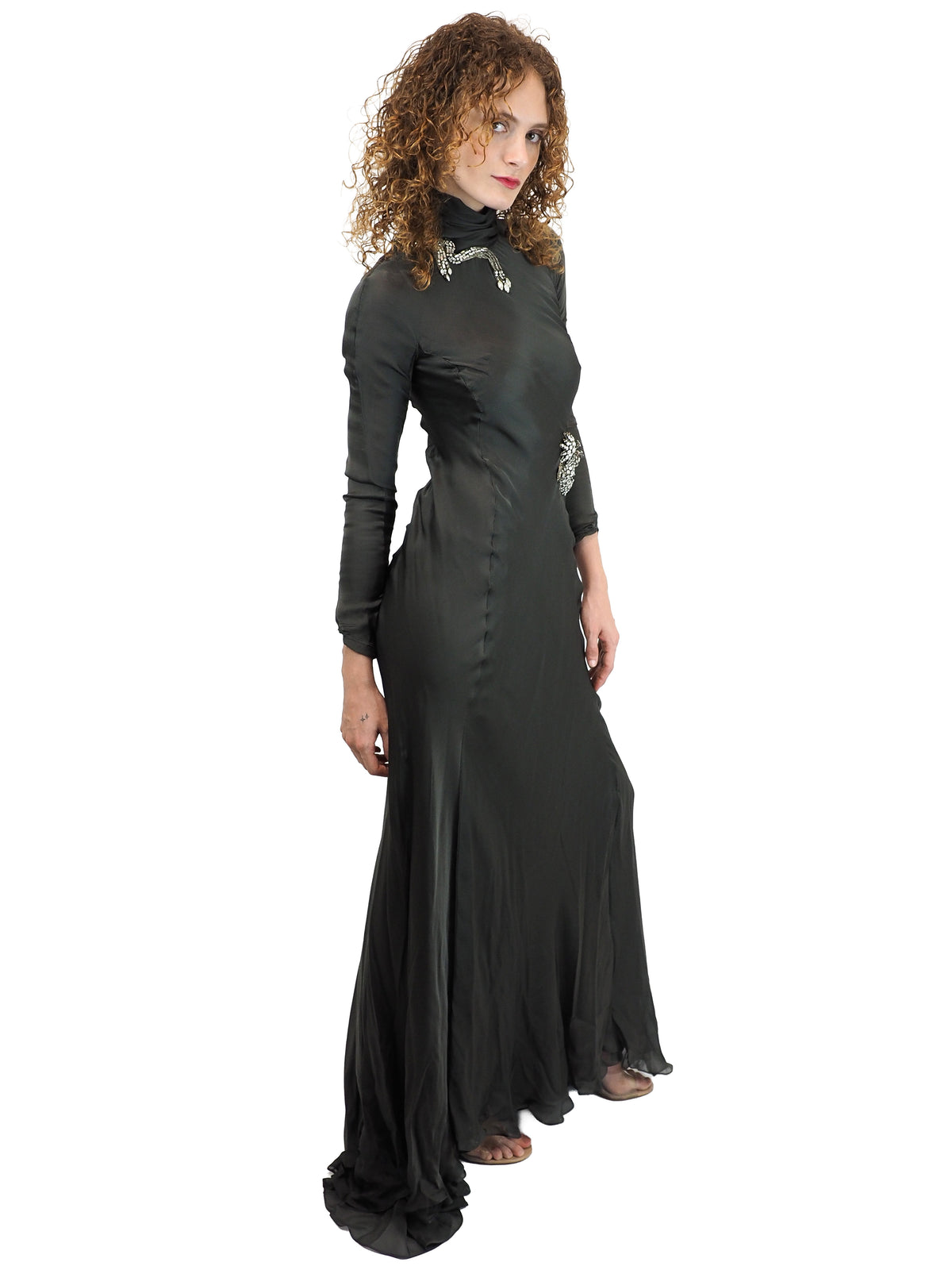 A vintage Alberta Ferretti floor-length green turtleneck gown with long sleeves and silver embellished details on the chest and waist