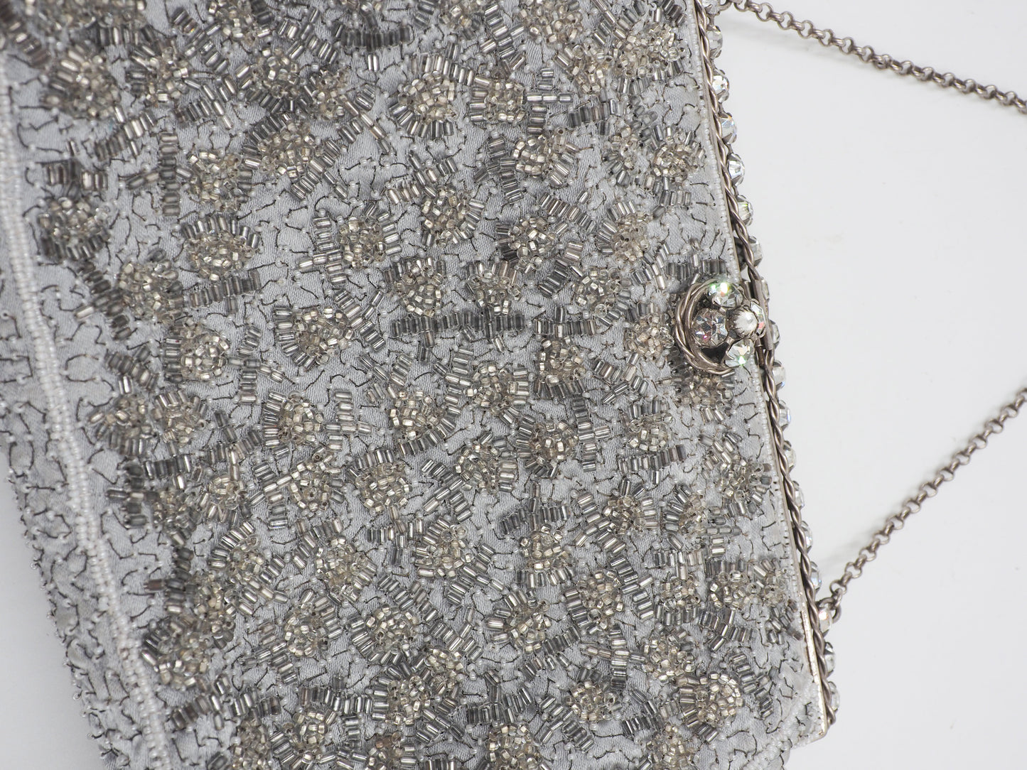 A vintage Elizabeth Arden silver-gray beaded evening clutch bag with a chain strap and a decorative crystal-embellished clasp