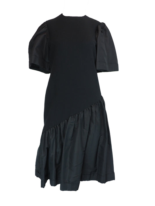 A black vintage 1980s pauline trigere dress with short puff sleeves, a matching waist belt, and a large bow detail at the side