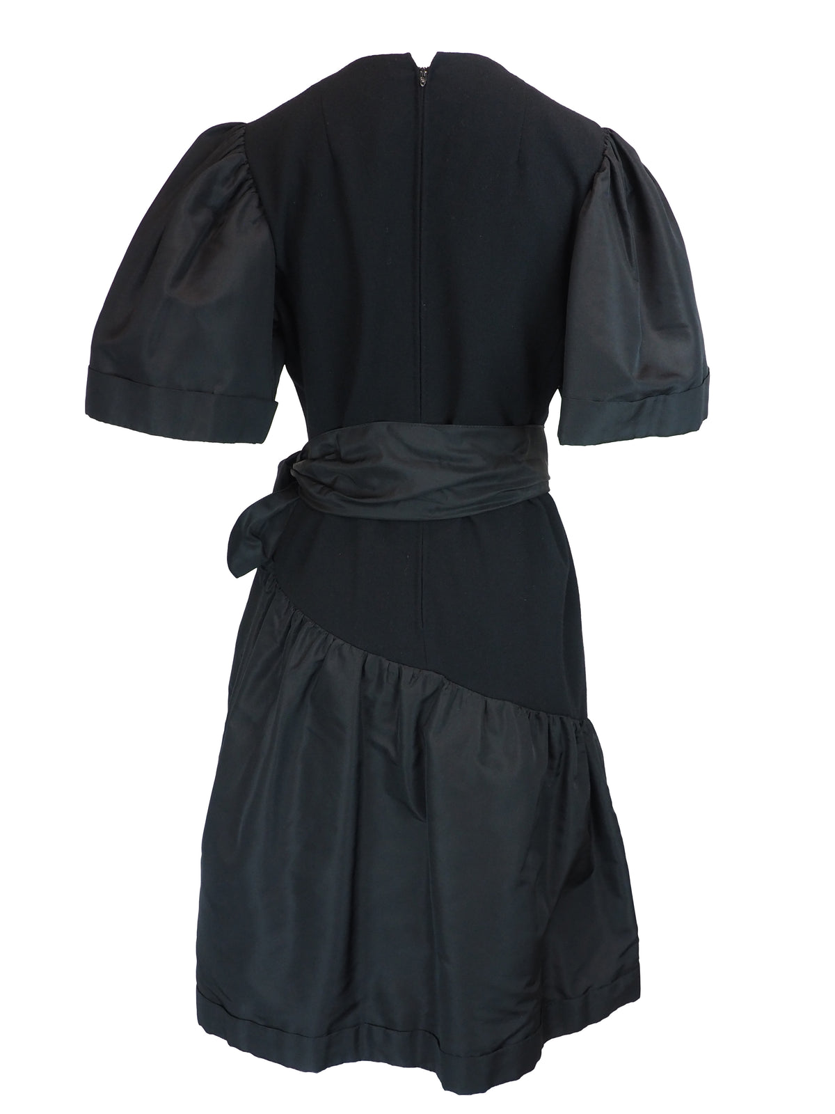 A black vintage 1980s pauline trigere dress with short puff sleeves, a matching waist belt, and a large bow detail at the side