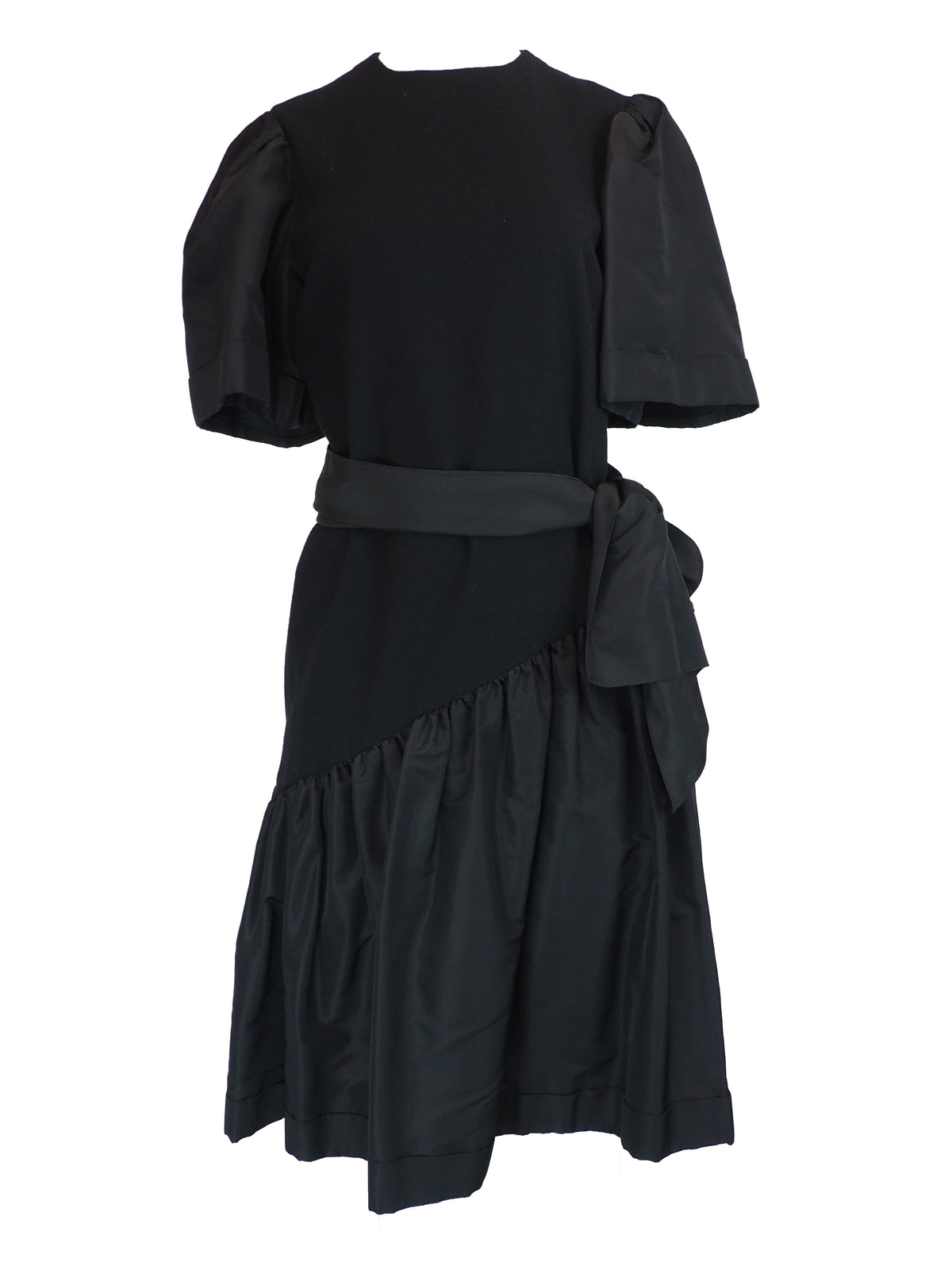 A black vintage 1980s pauline trigere dress with short puff sleeves, a matching waist belt, and a large bow detail at the side