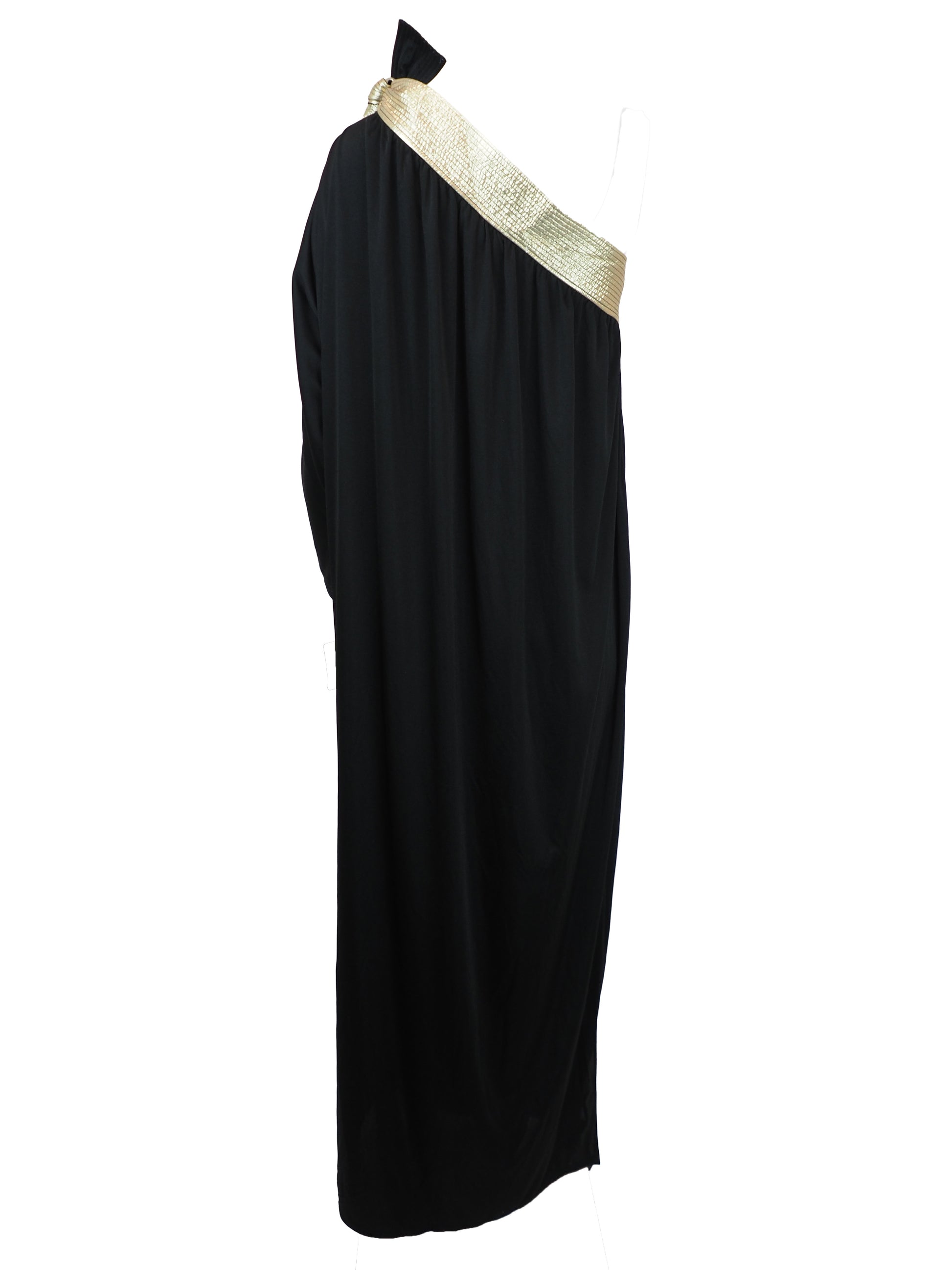 A vintage bill Tice black one-shoulder maxi dress with a wide, textured gold shoulder strap and a matching gold bow detail at the neckline