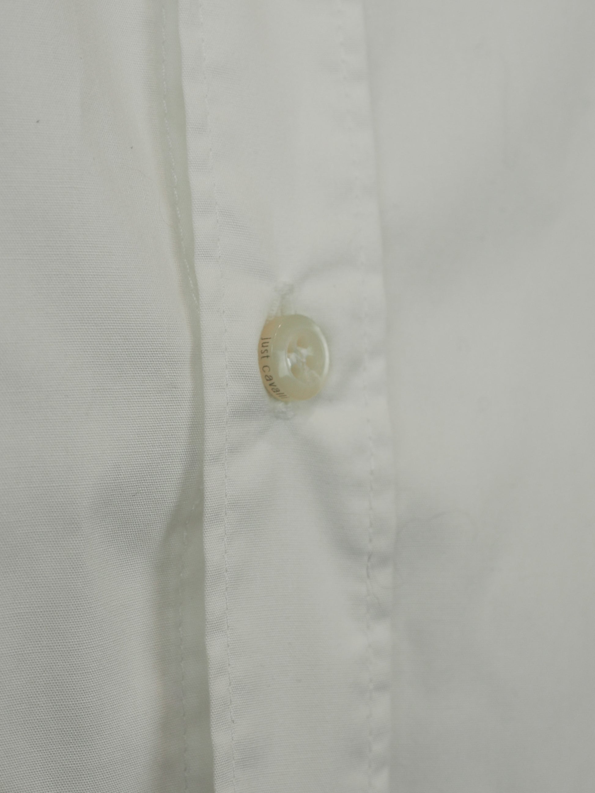 A vintage Roberto cavalli white long-sleeve button-down shirt with black and silver patterned stud trim on the collar and cuffs