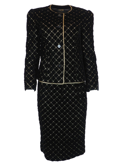 A vintage Celine black velvet two-piece suit set consisting of a cropped jacket and a matching pencil skirt, both decorated with a gold diamond lattice pattern and gold trim