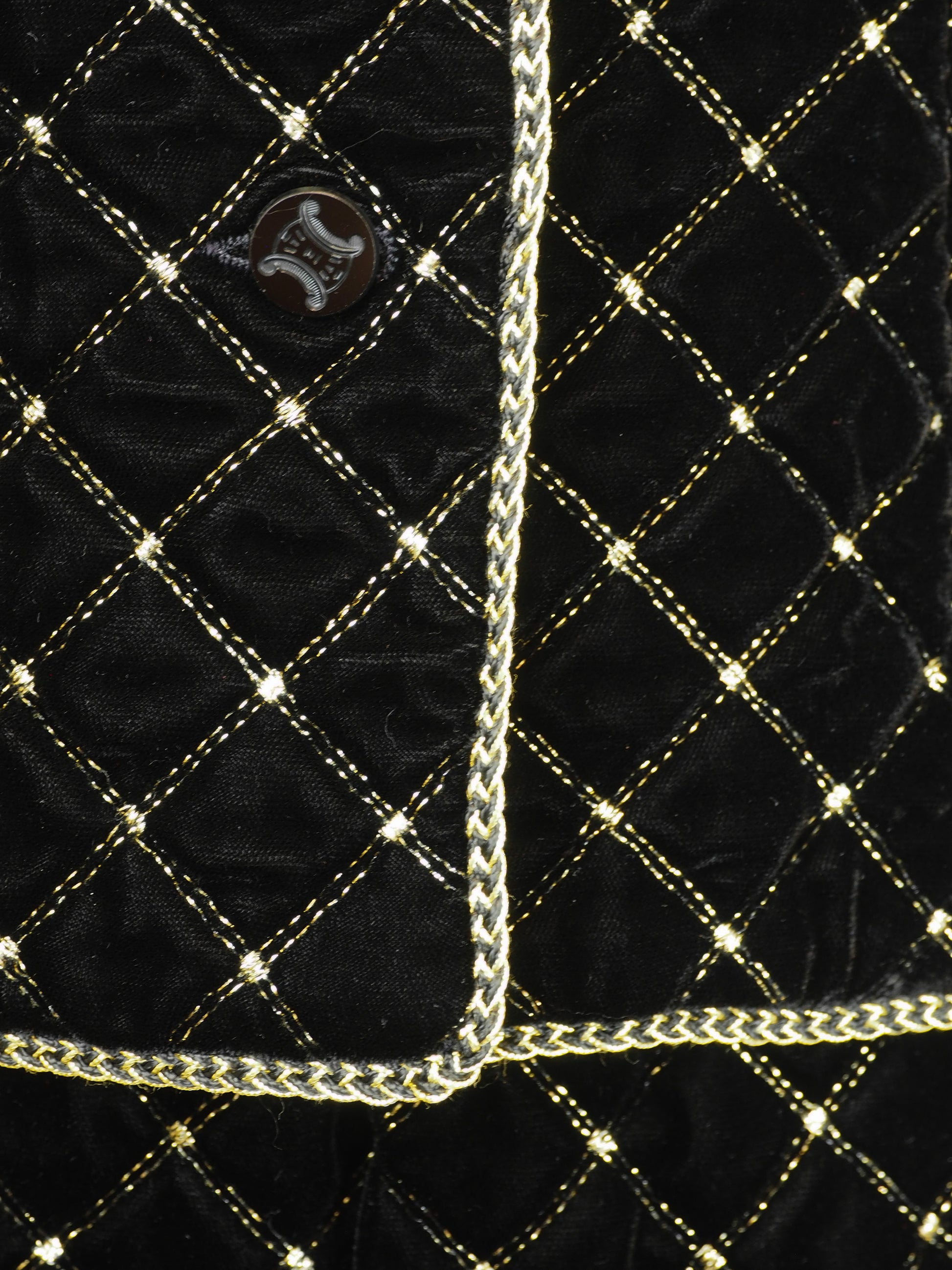 A vintage Celine black velvet two-piece suit set consisting of a cropped jacket and a matching pencil skirt, both decorated with a gold diamond lattice pattern and gold trim