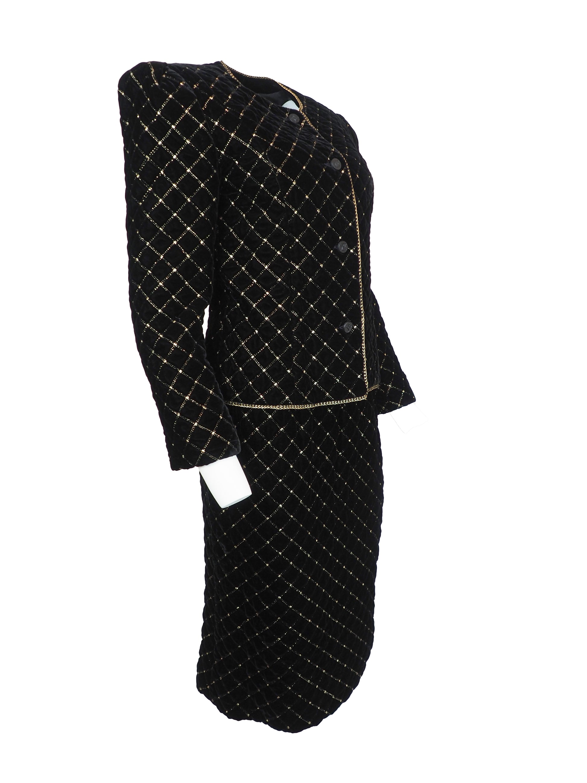 A vintage Celine black velvet two-piece suit set consisting of a cropped jacket and a matching pencil skirt, both decorated with a gold diamond lattice pattern and gold trim