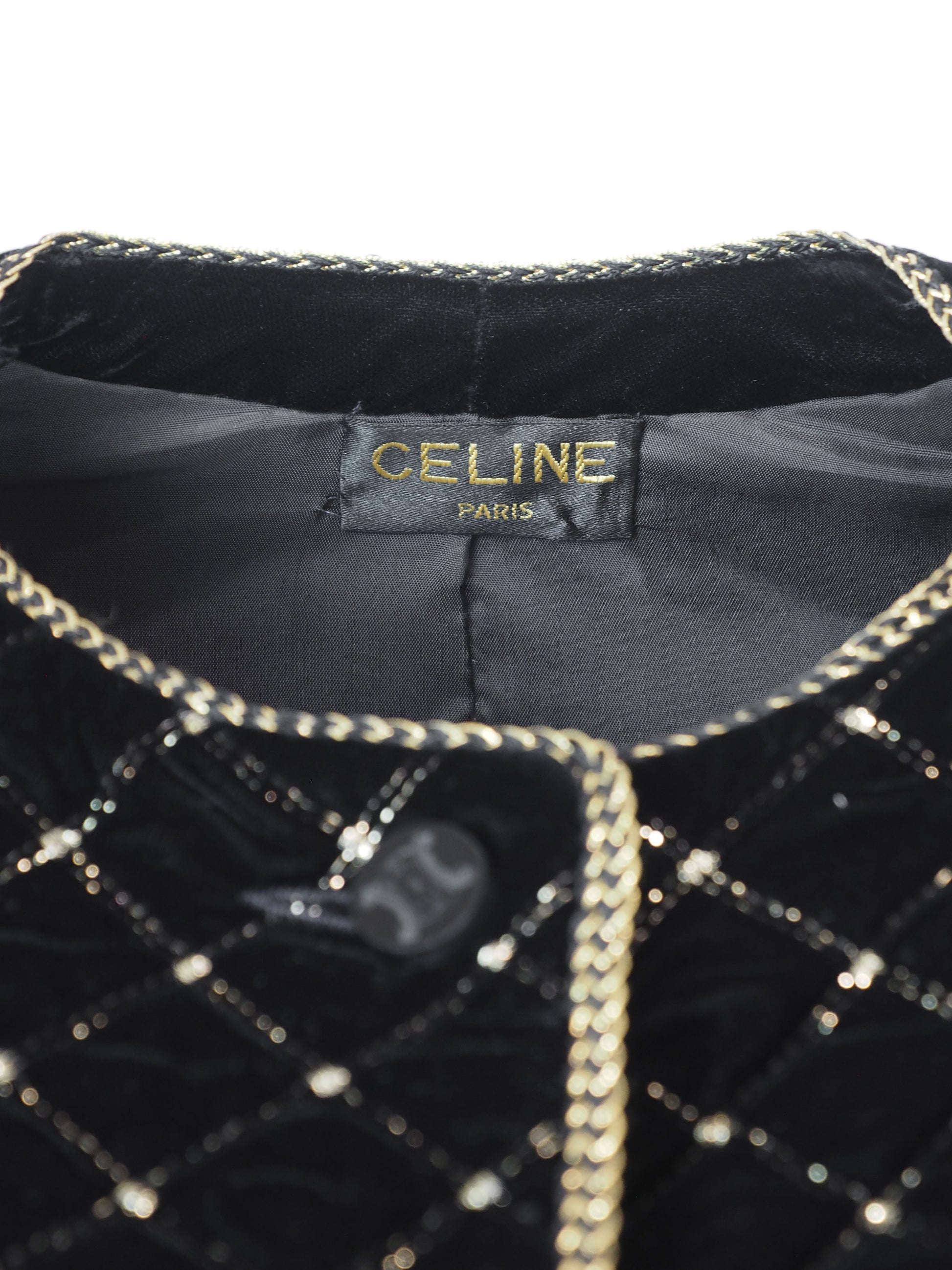 A vintage Celine black velvet two-piece suit set consisting of a cropped jacket and a matching pencil skirt, both decorated with a gold diamond lattice pattern and gold trim