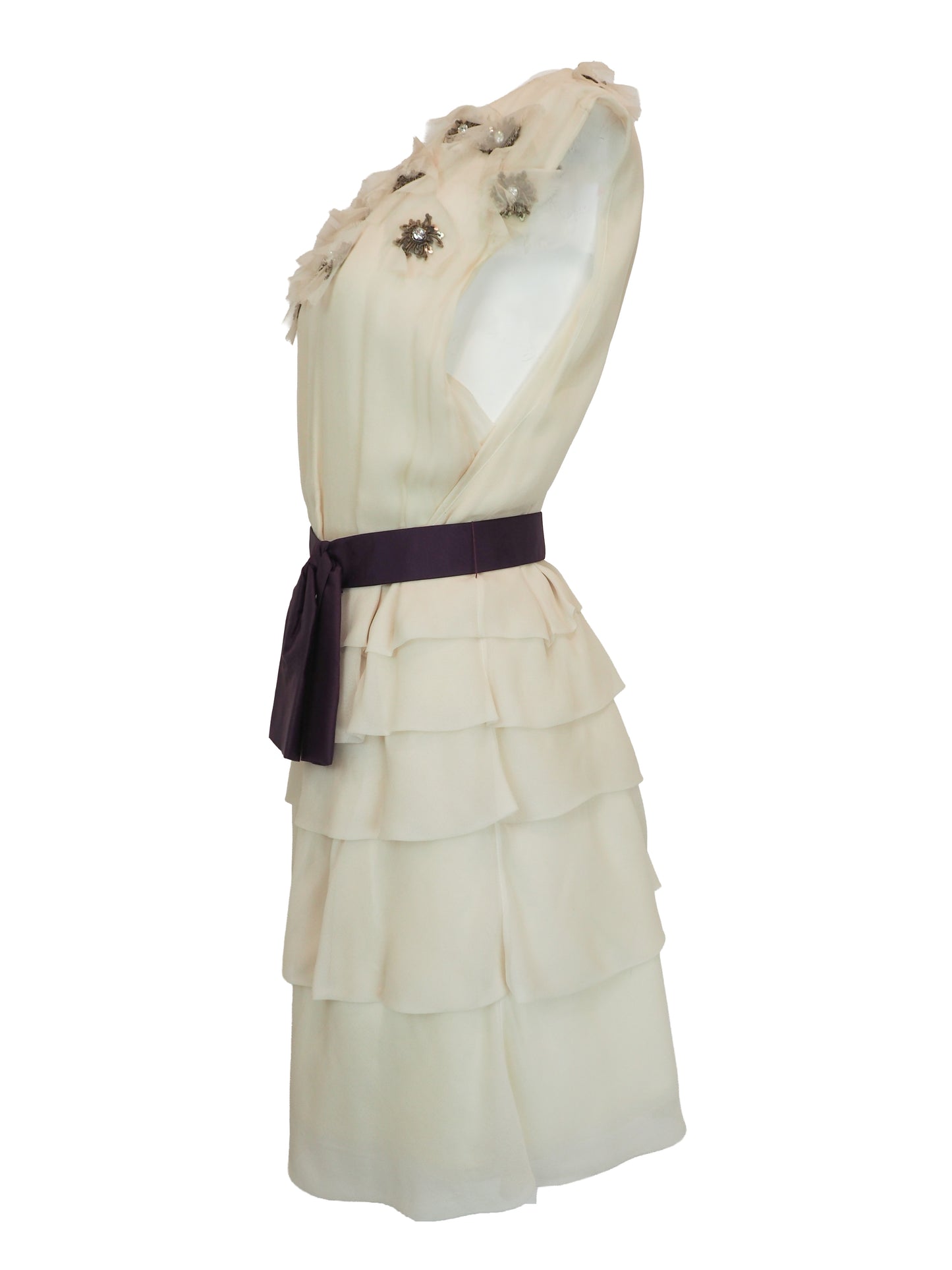 A vintage Chloe Y2K off-white sleeveless ruffled dress with floral embellishments on the bodice and a dark purple waist belt 