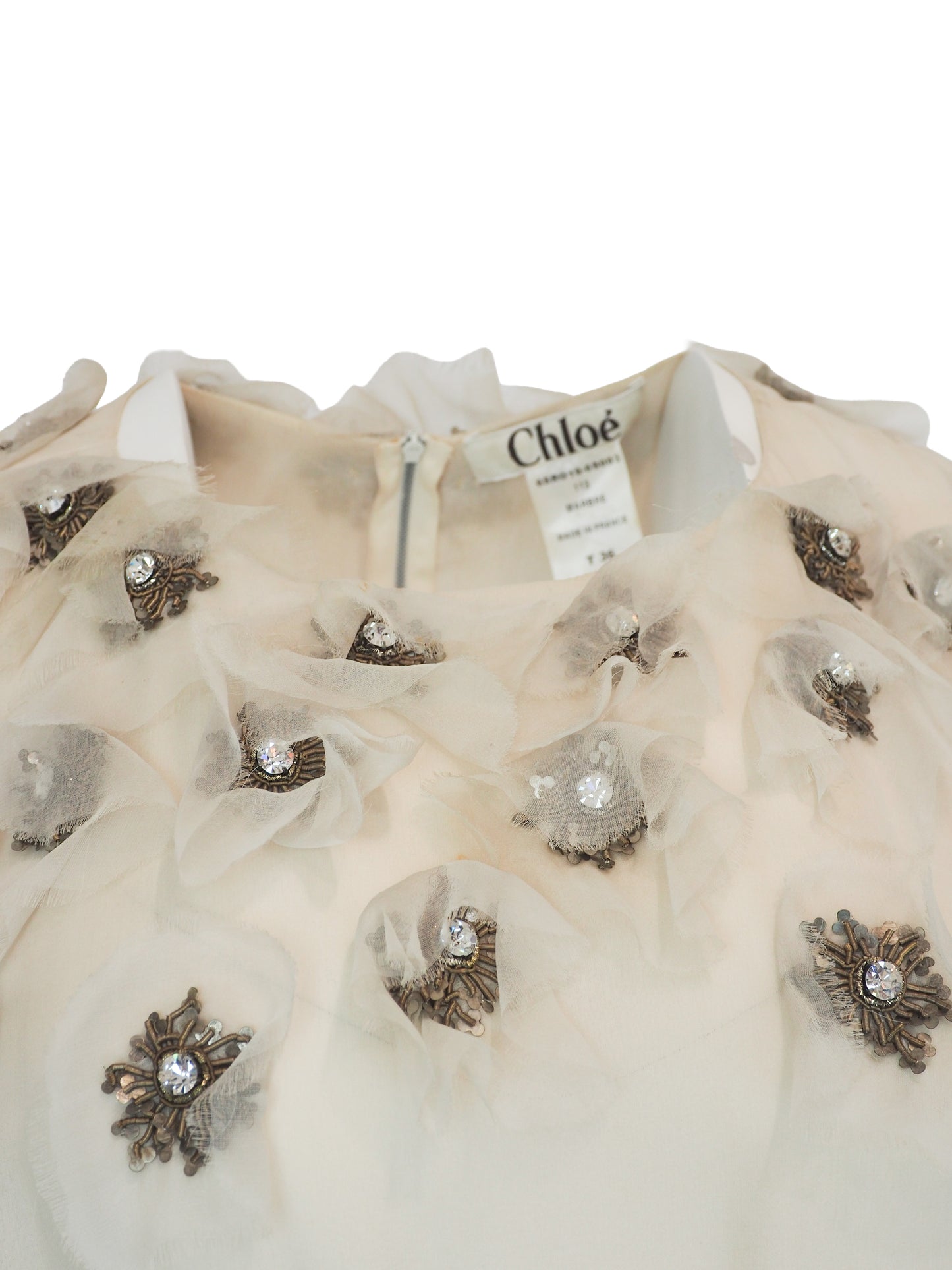 A vintage Chloe Y2K off-white sleeveless ruffled dress with floral embellishments on the bodice and a dark purple waist belt 