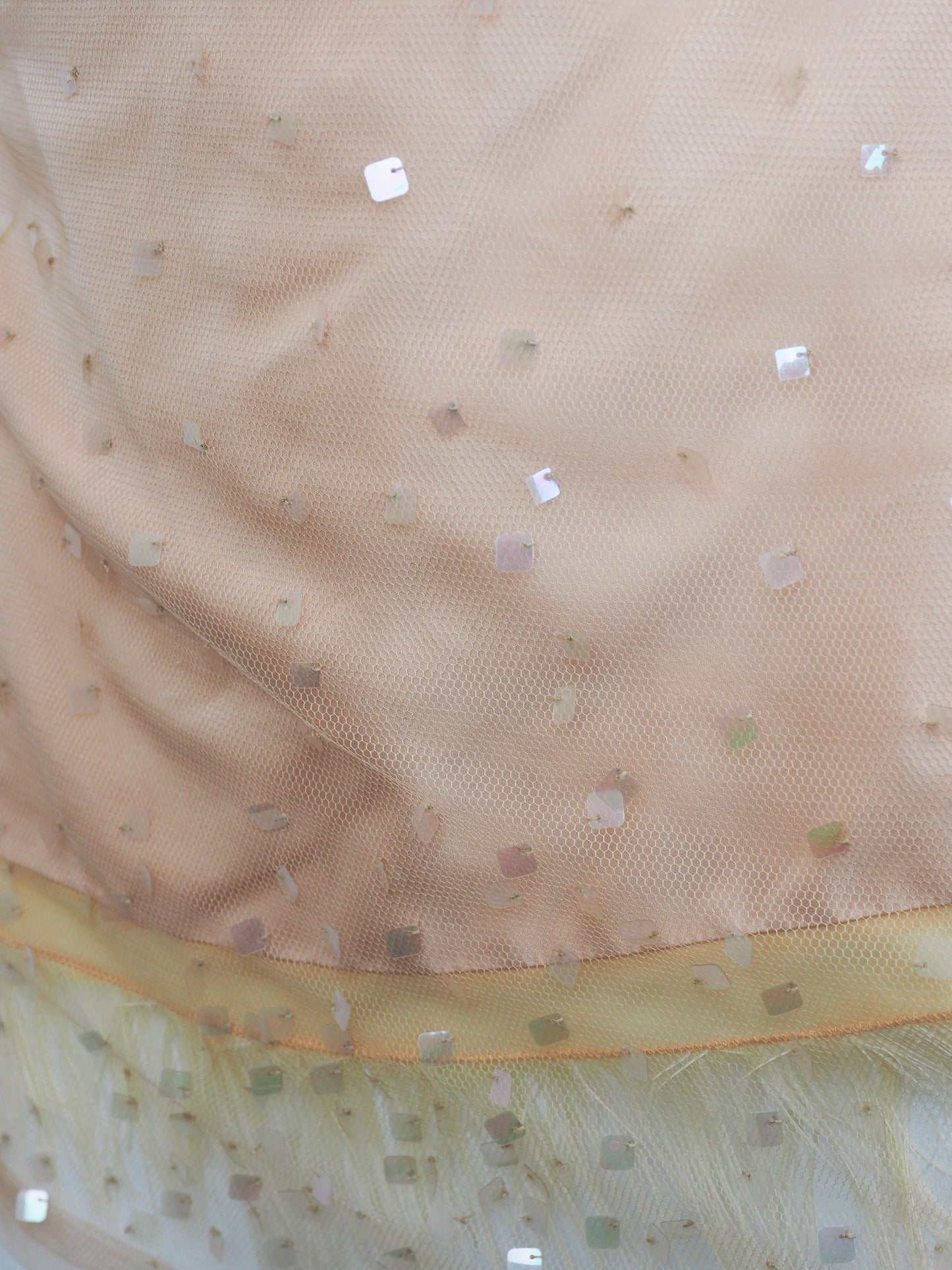 A vintage Donna Karan pink colored sheer mesh camisole top with thin straps, embellished with scattered sequins and a feather hem