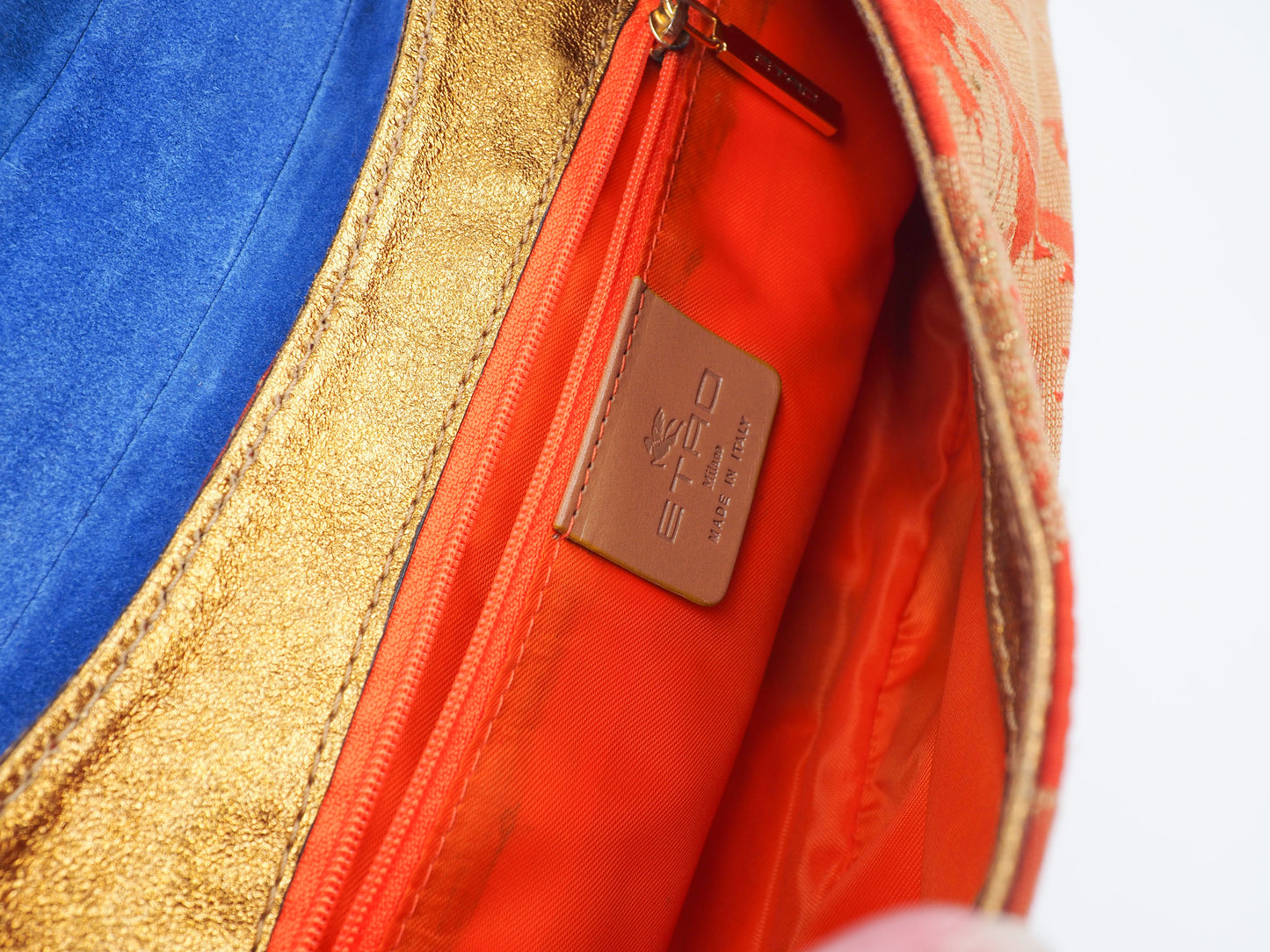 A vintage etro small shoulder bag with a red and gold floral jacquard pattern, featuring a gold-tone chain strap and a decorative red and gold clasp 