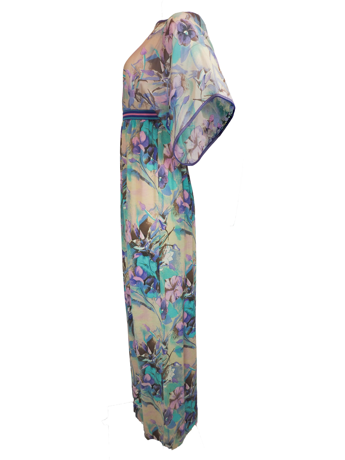 A vintage long, loose kaftan dress featuring a vibrant floral print in shades of purple, teal, and blue over a beige background, with a thin blue and red striped waistband.