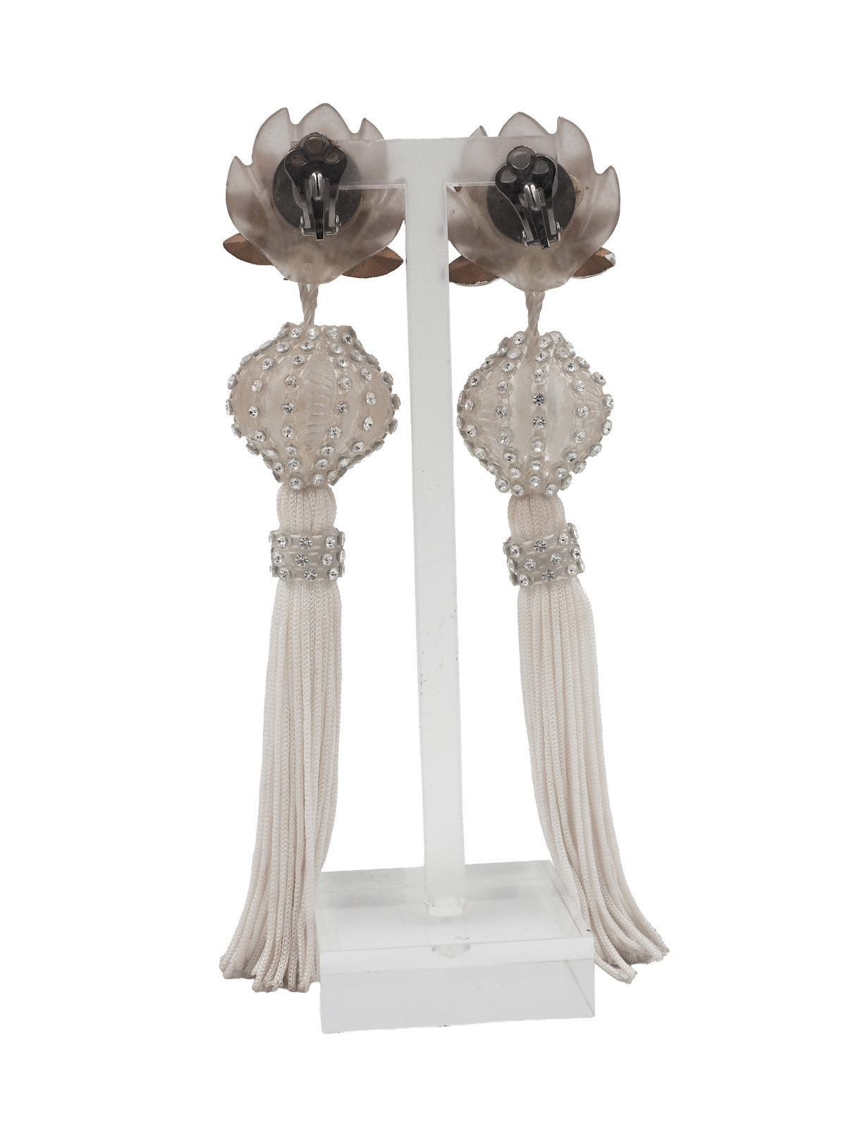 A pair of long, ornate drop earrings with clear faceted crystal flower tops, cream beadwork, and long cream tassel fringe