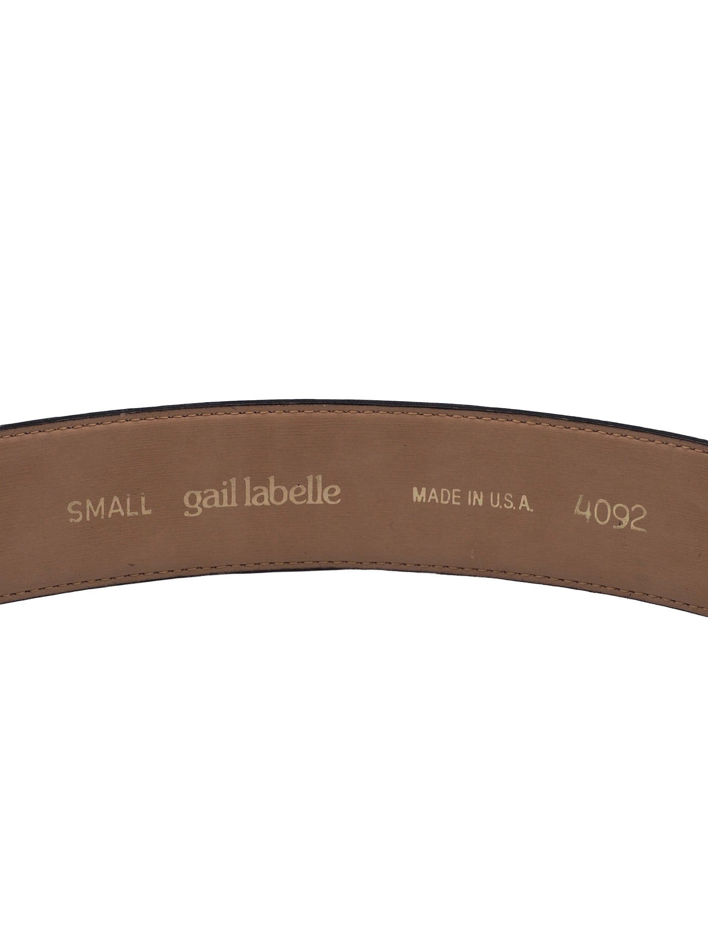 A vintage Gail labelle black leather belt with a large, textured gold buckle featuring a stylized animal motif