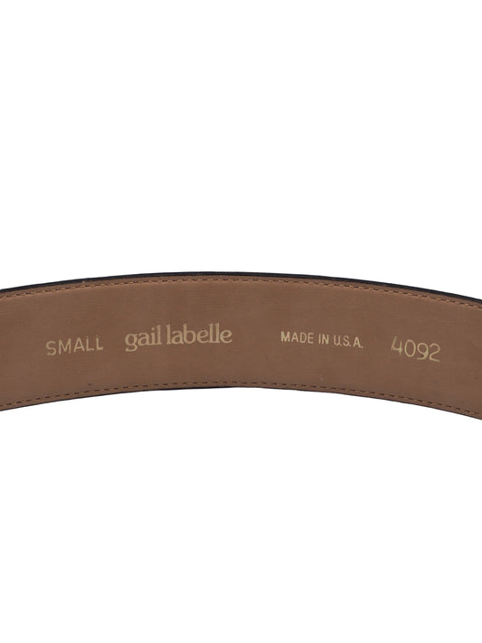 A vintage Gail labelle black leather belt with a large, textured gold buckle featuring a stylized animal motif