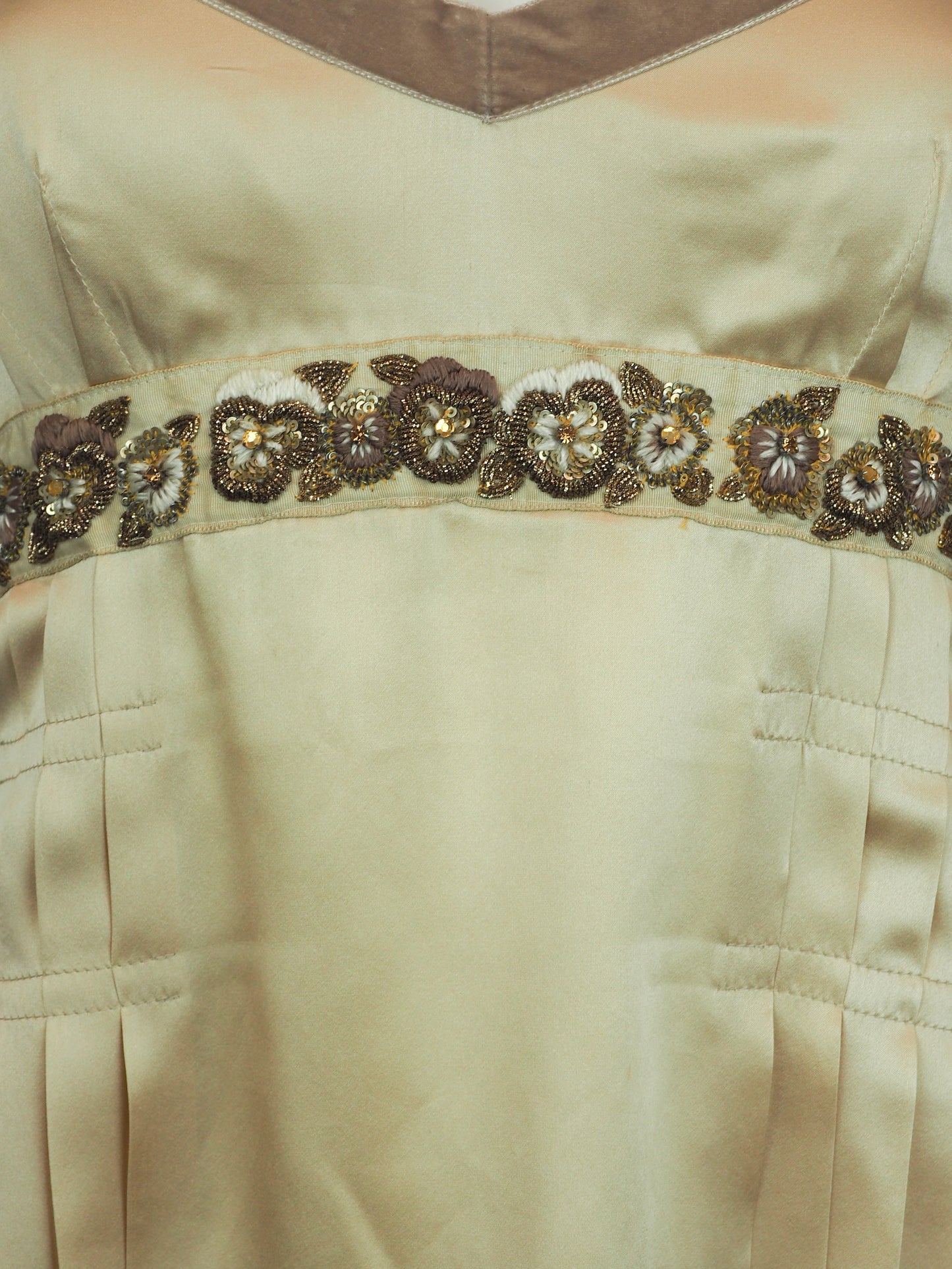 A vintage John galliano Y2K light beige satin camisole top with a V-neckline, thin shoulder straps, a decorative floral embroidered waistband, and pleated detailing on the front