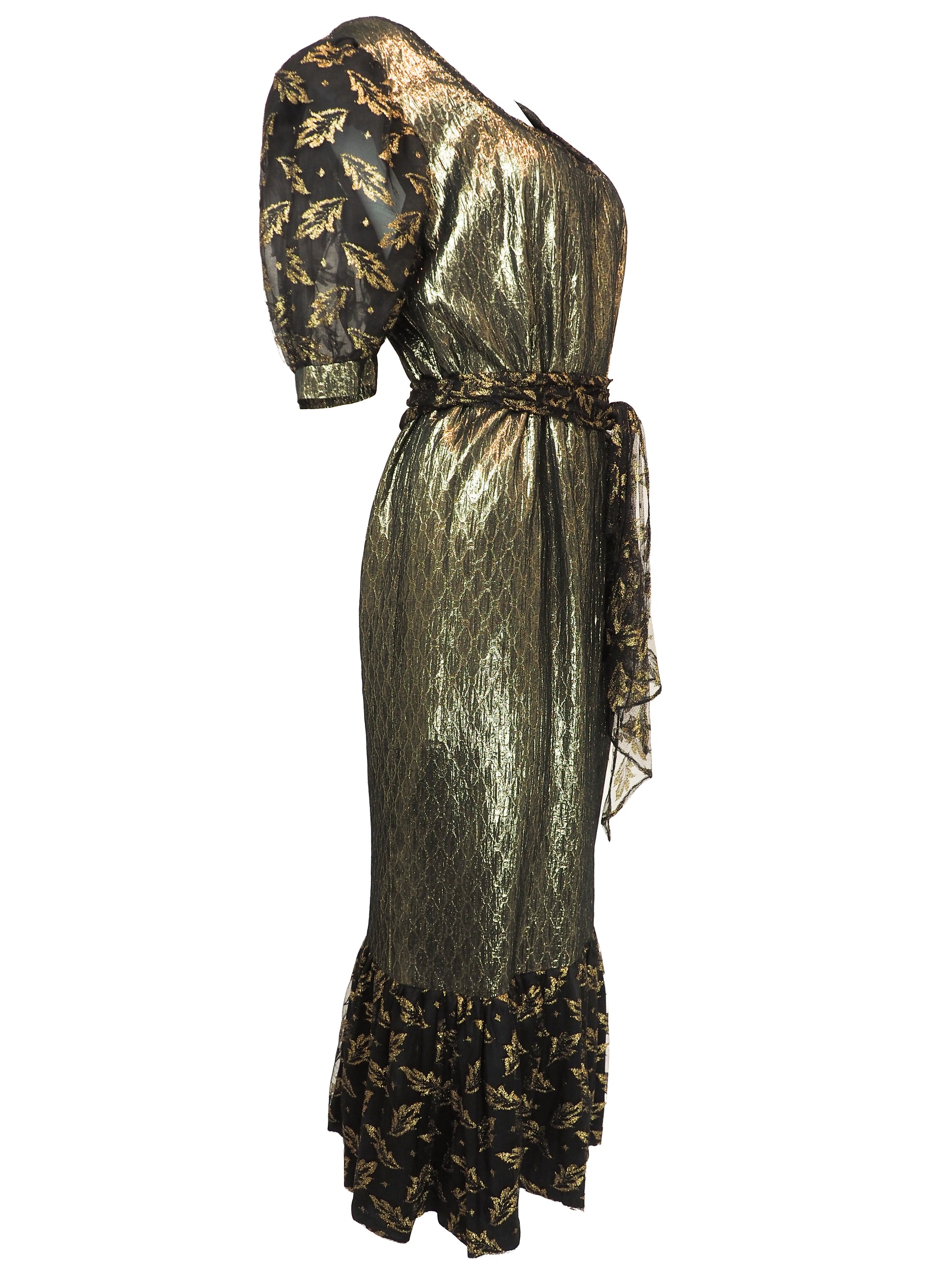 A vintage 1980s metallic gold and black patterned midi dress with puff sleeves, a matching waist tie, and a ruffled hem