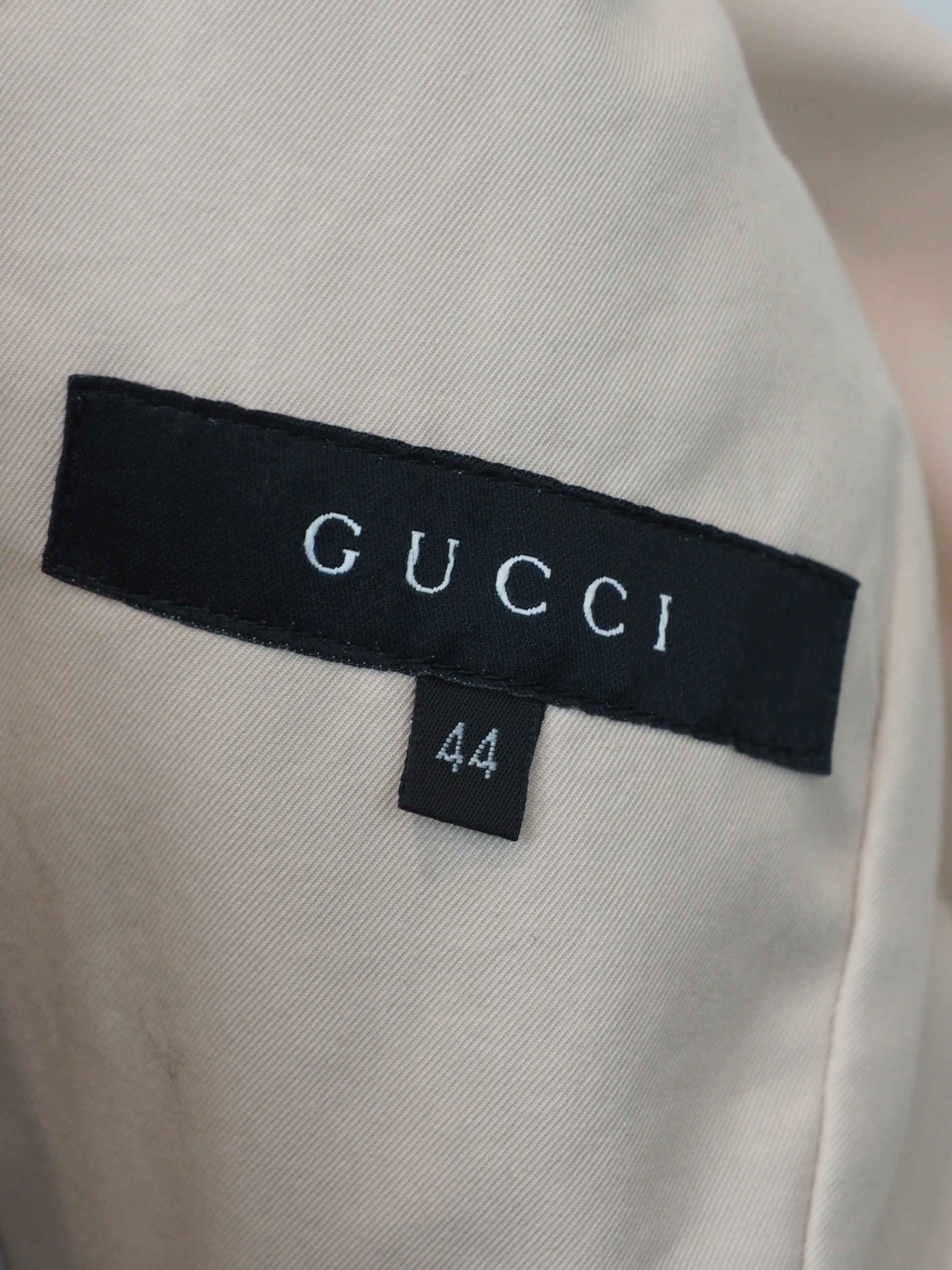 A women's vintage Tom Ford Gucci 2003 beige utility-style blazer jacket with a notched lapel collar, buttoned flap chest pockets, a gathered waist seam, and two large front flap pockets