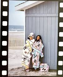 Brandi Quinones and another model standing in front of a beach shed wearing Chanell the 1994 terrycloth collection