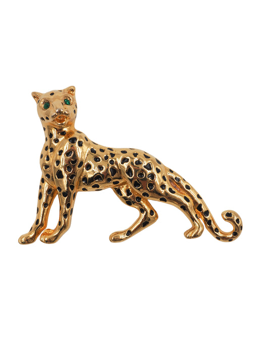 A vintage gold leopard-shaped brooch with black enamel spots and green gemstone eyes