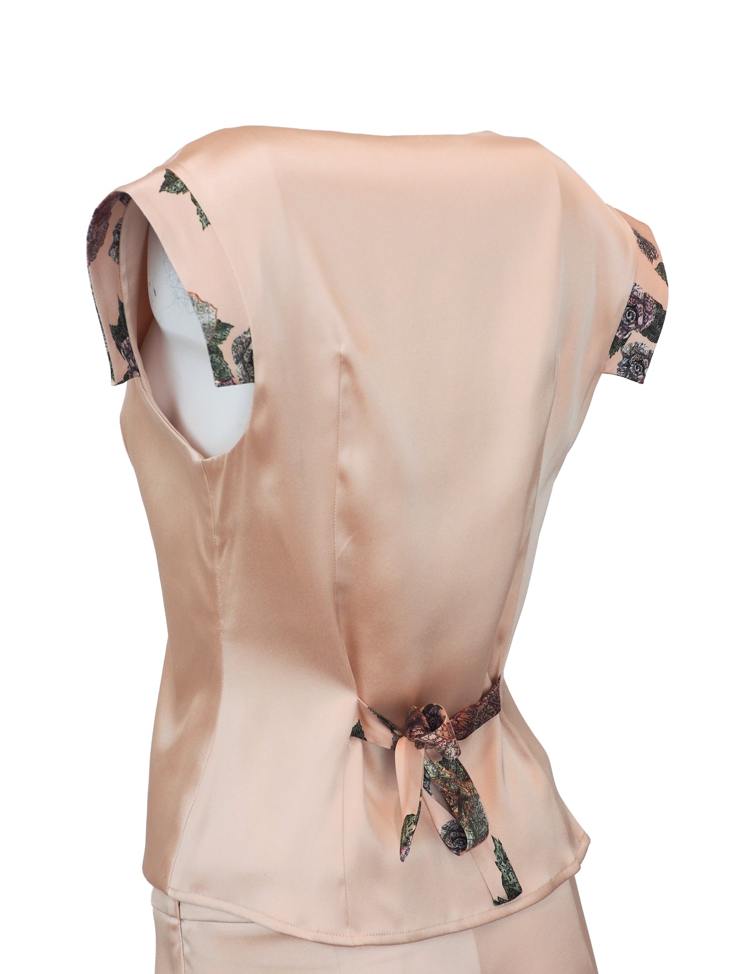 Le Perla Maps in Bloom vintage. A two-piece peach-colored satin set consisting of a sleeveless button-front top with patterned cap sleeves and matching slim trousers, shown on a plain white background.