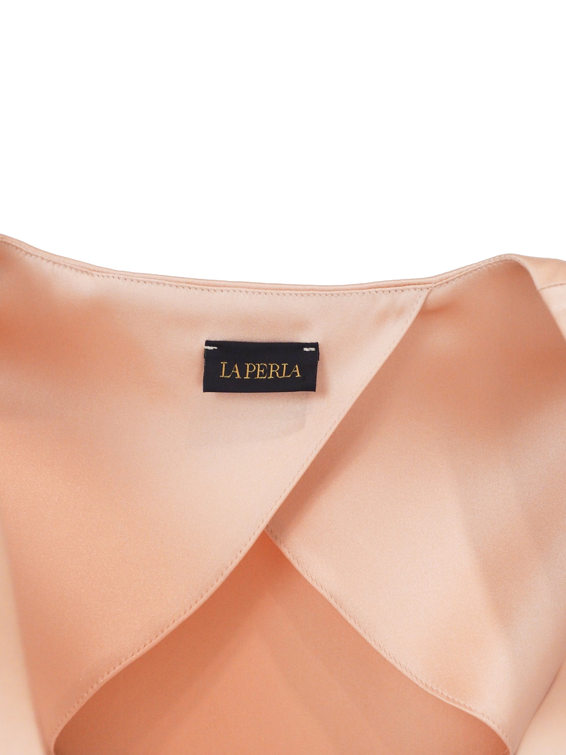 Le Perla Maps in Bloom vintage. A two-piece peach-colored satin set consisting of a sleeveless button-front top with patterned cap sleeves and matching slim trousers, shown on a plain white background.