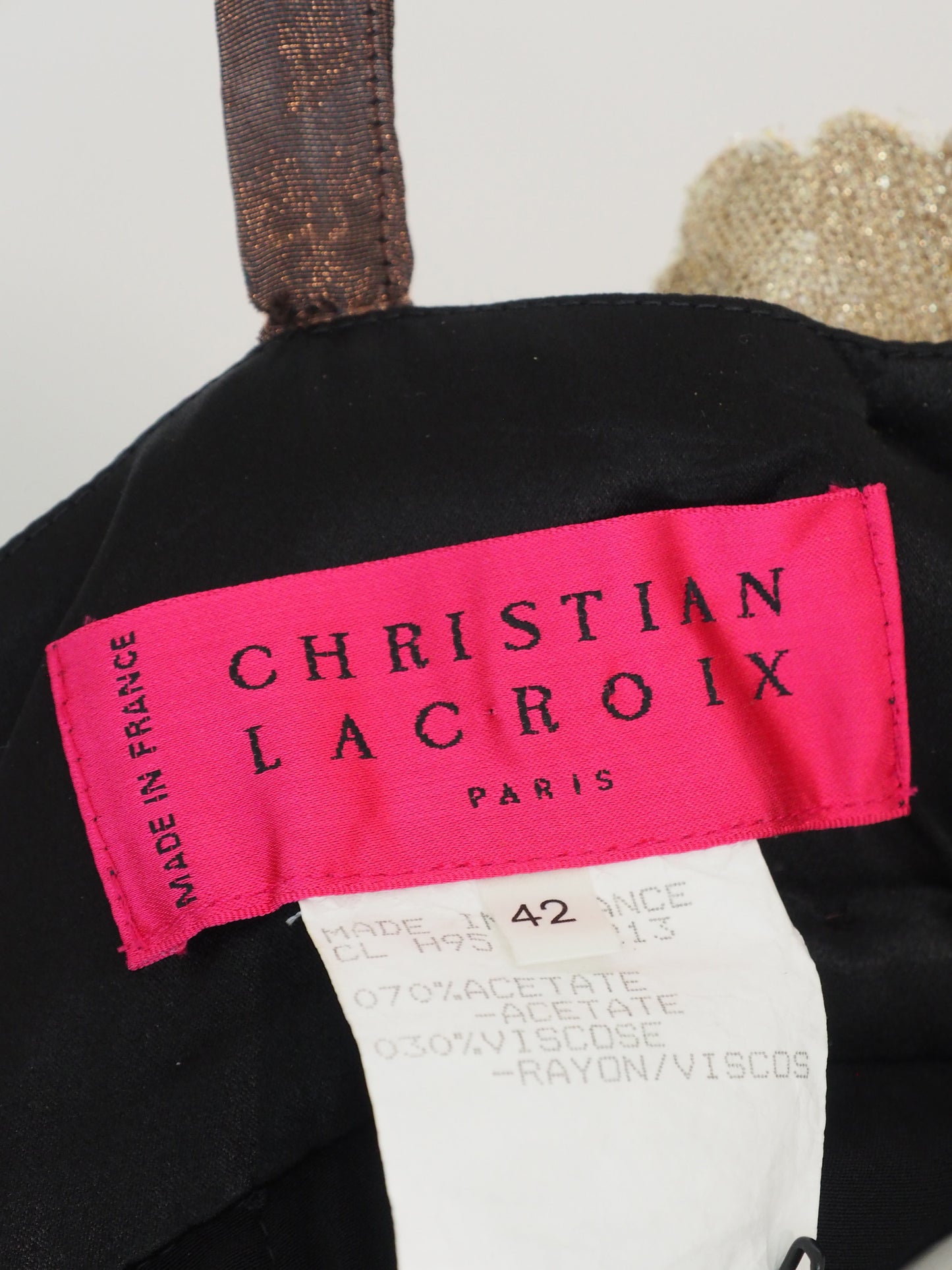 A vintage christian Lacroix runway sleeveless maxi dress with a sheer floral lace pattern in earthy tones of brown, green, and gold, featuring a cream lace bodice and a dark brown satin waist tie