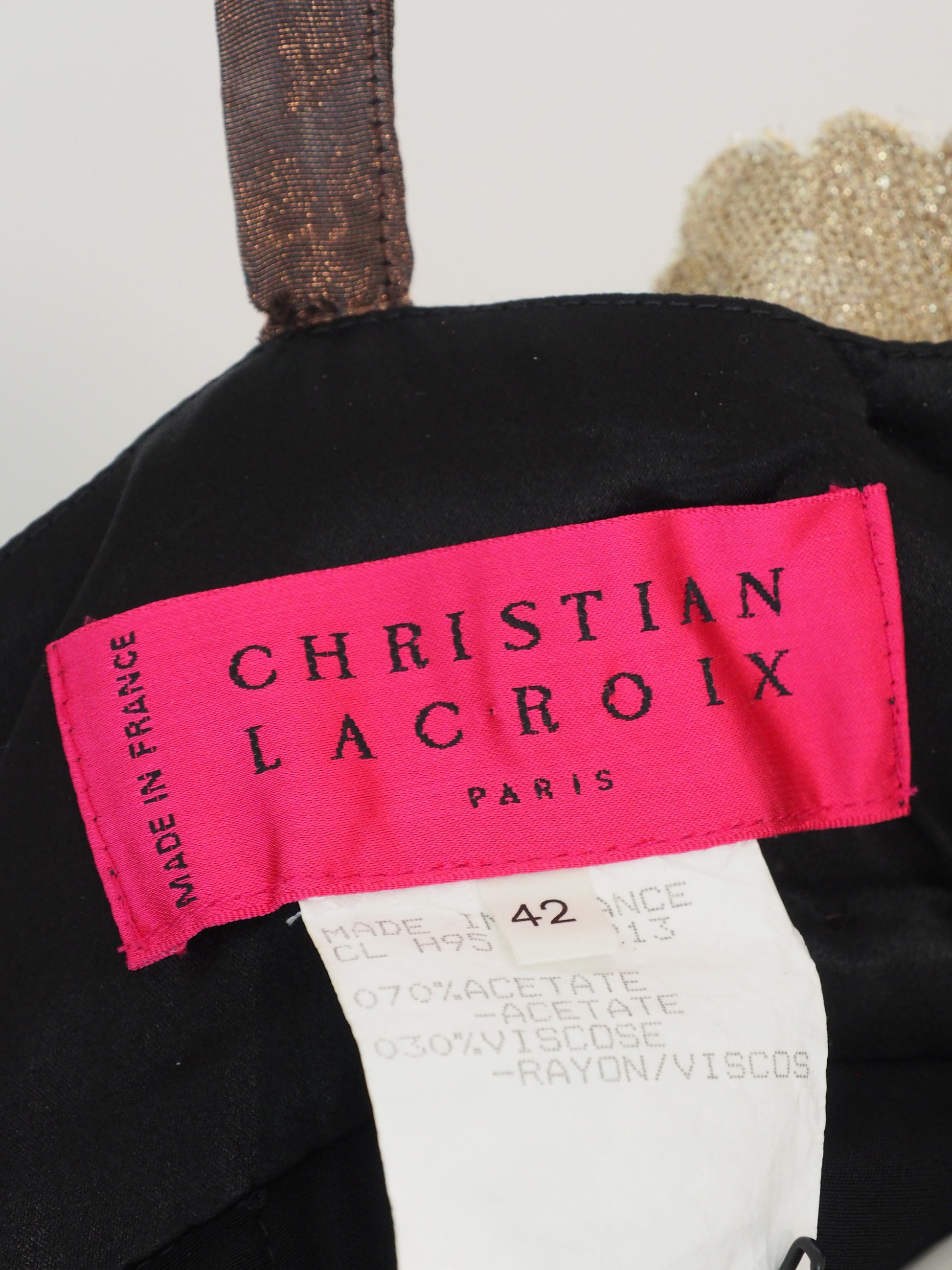 A vintage christian Lacroix runway sleeveless maxi dress with a sheer floral lace pattern in earthy tones of brown, green, and gold, featuring a cream lace bodice and a dark brown satin waist tie