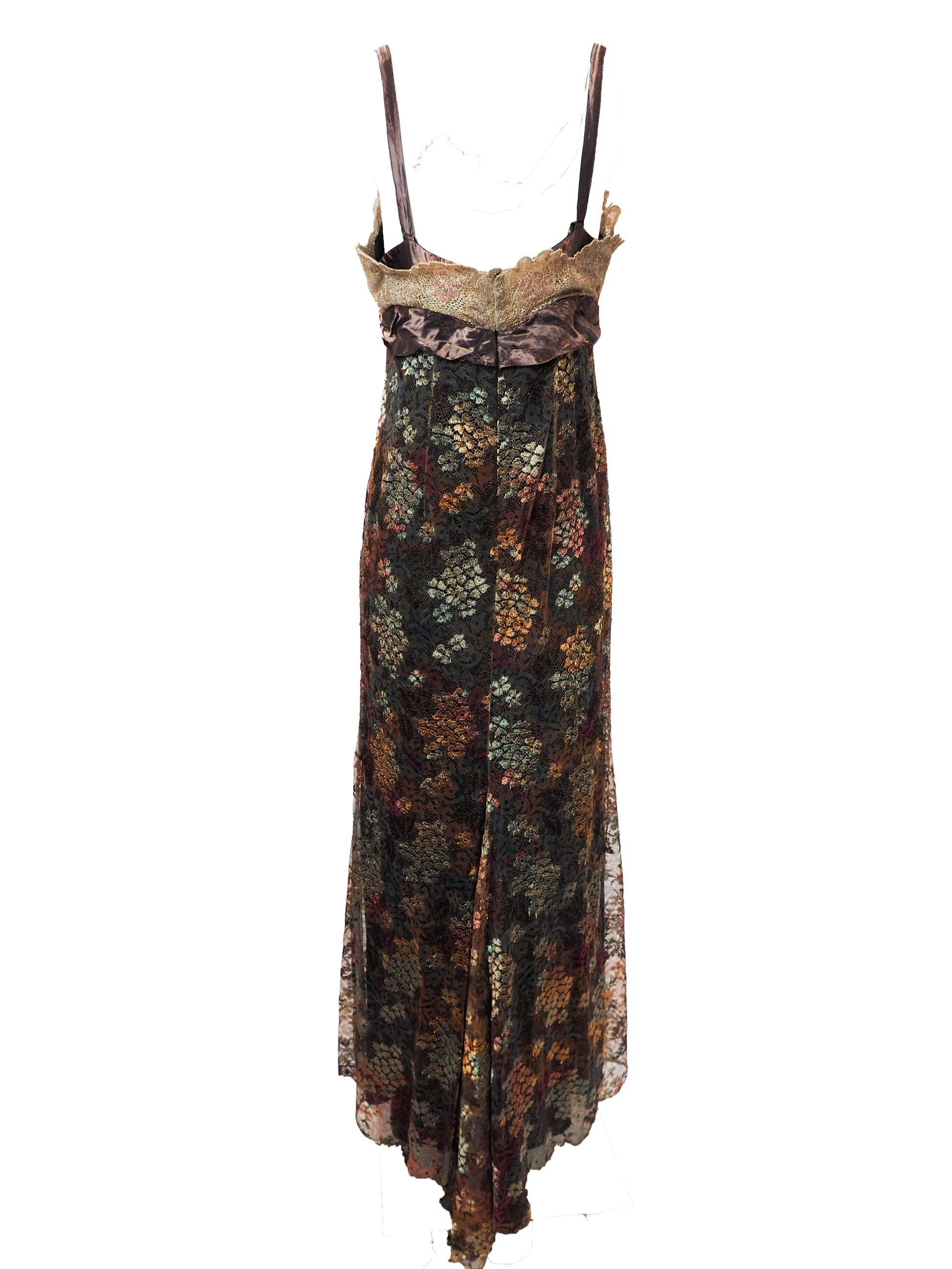 A vintage christian Lacroix runway sleeveless maxi dress with a sheer floral lace pattern in earthy tones of brown, green, and gold, featuring a cream lace bodice and a dark brown satin waist tie