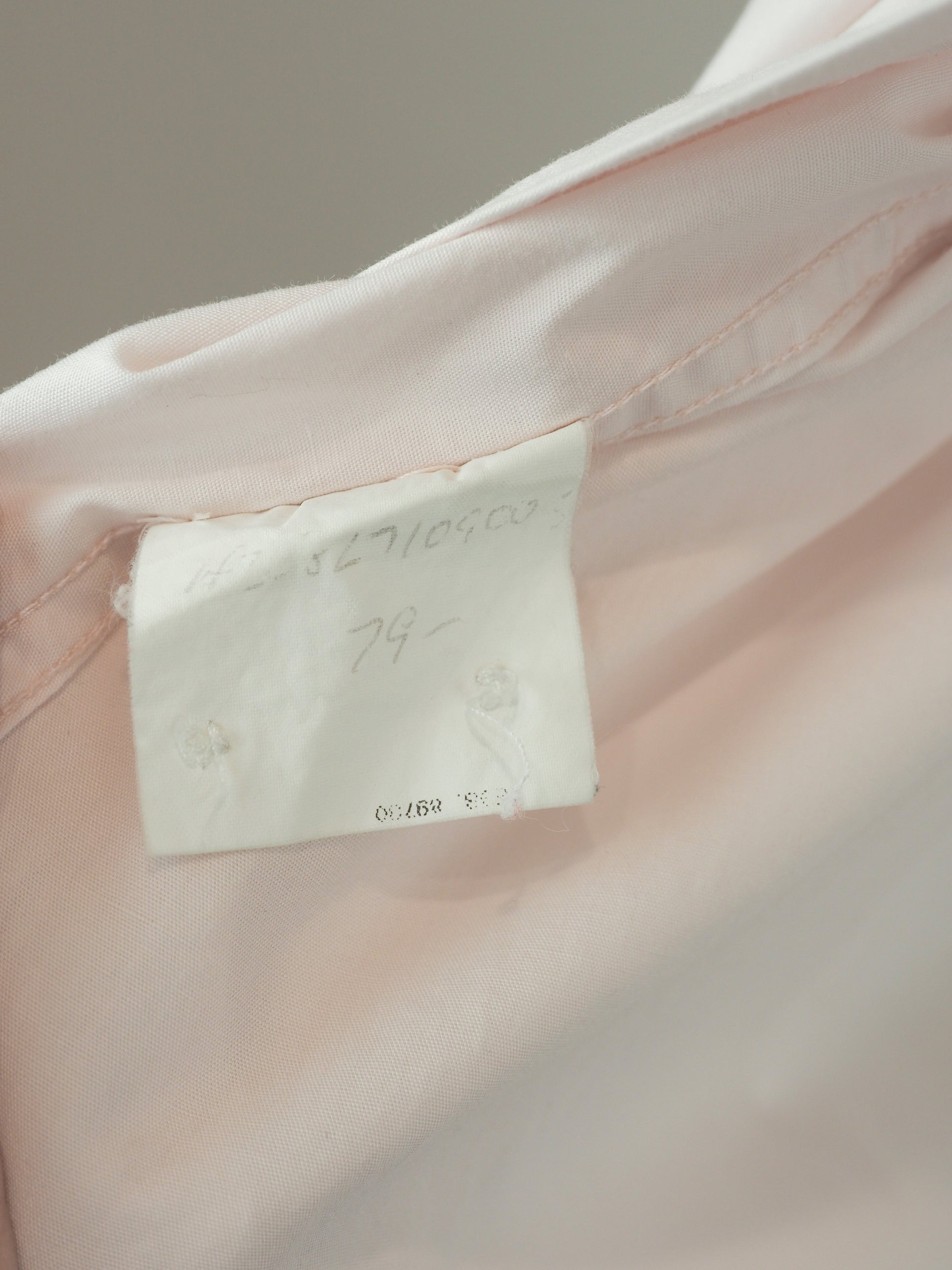 A vintage Maison Martin margiela 2001 pale blush pink oversized button-down shirt dress with a pointed collar, long sleeves, and a small black embroidered clover on the left chest