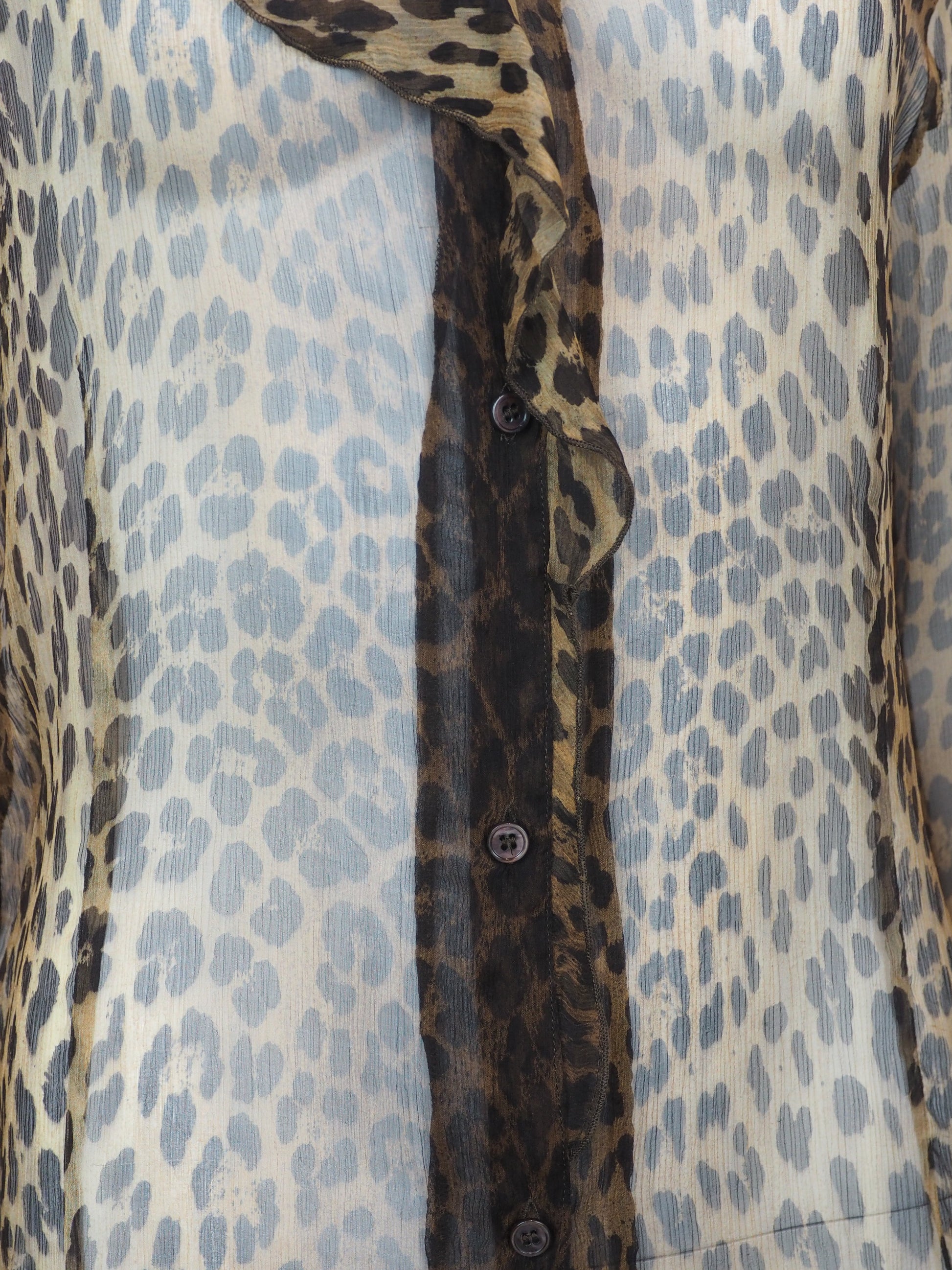 A vintage moschino sheer leopard-print blouse with a ruffled collar, button-front center panel, and matching ruffled cuffs