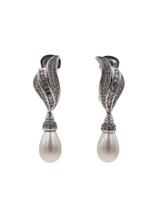 A pair of silver-toned drop earrings featuring a curved, pavé-set crystal design above a teardrop-shaped white pearl