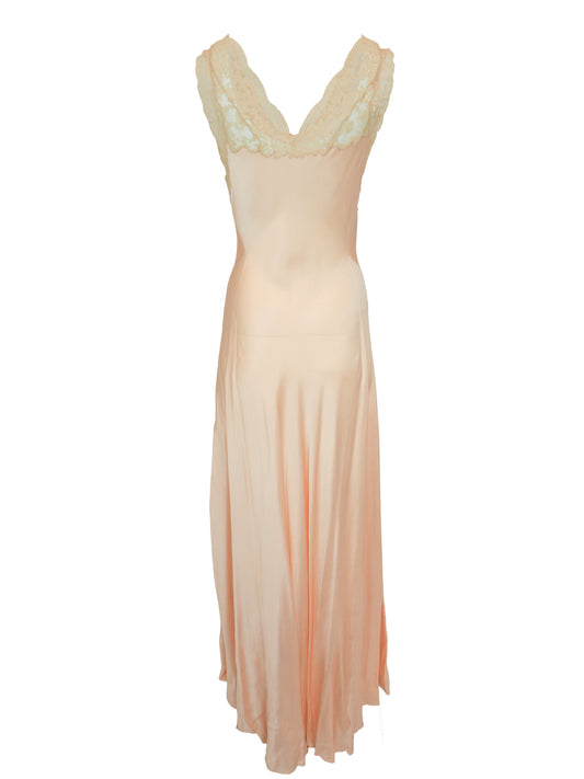 A vintage 1920s 1930s sleeveless peach maxi slip dress with a satin-like skirt and a light ivory lace embroidered bodice
