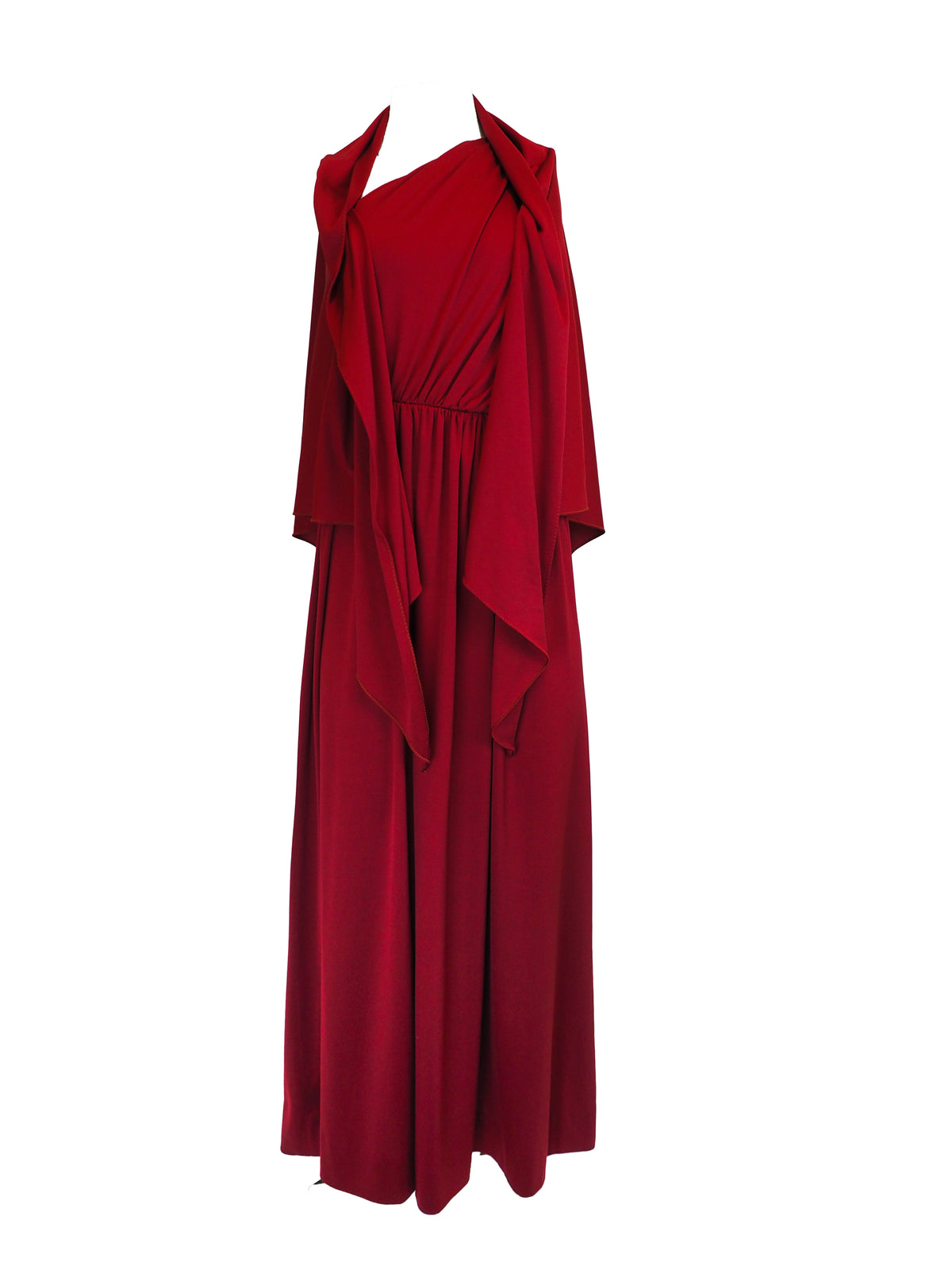 A vintage 1970s red one-shoulder maxi dress with a draped, wrap-style bodice and a matching waist tie
