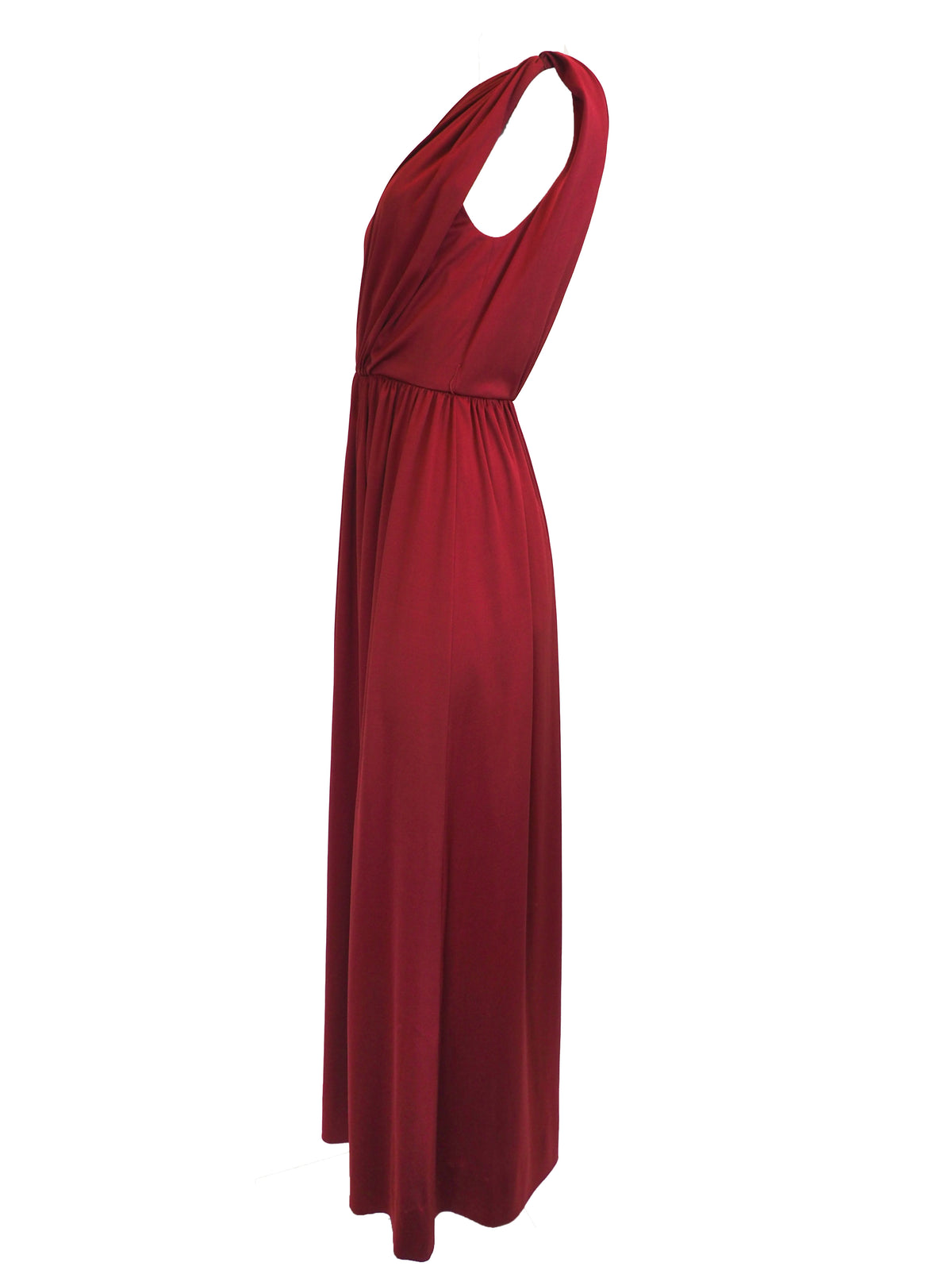 A vintage 1970s red one-shoulder maxi dress with a draped, wrap-style bodice and a matching waist tie