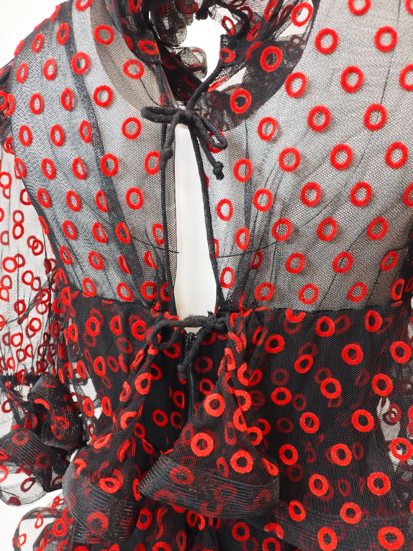 A vintage Arnold Scaasi designer black sheer mesh dress with a red and black poppy print, featuring a ruffled high neck, long puff sleeves, and a tiered ruffled skirt