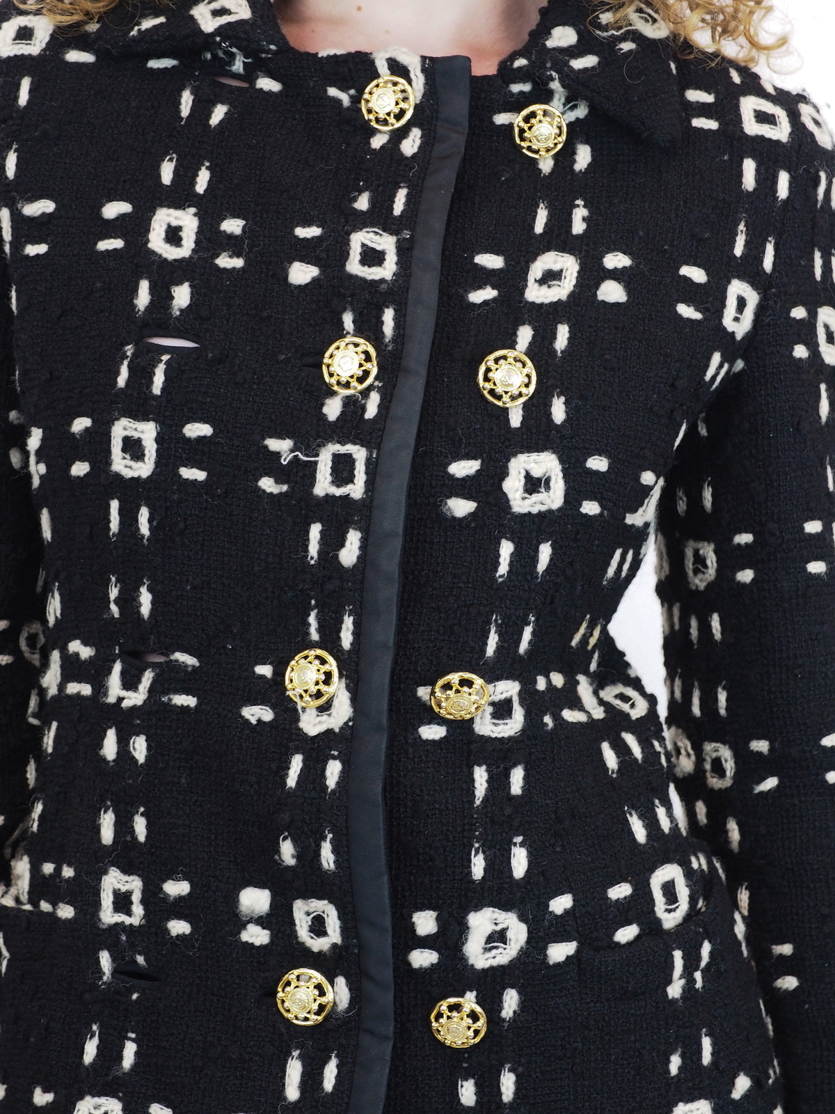 A vintage 1992 Gianni Versace black tweed jacket and matching mini skirt set with a beige geometric pattern and gold buttons