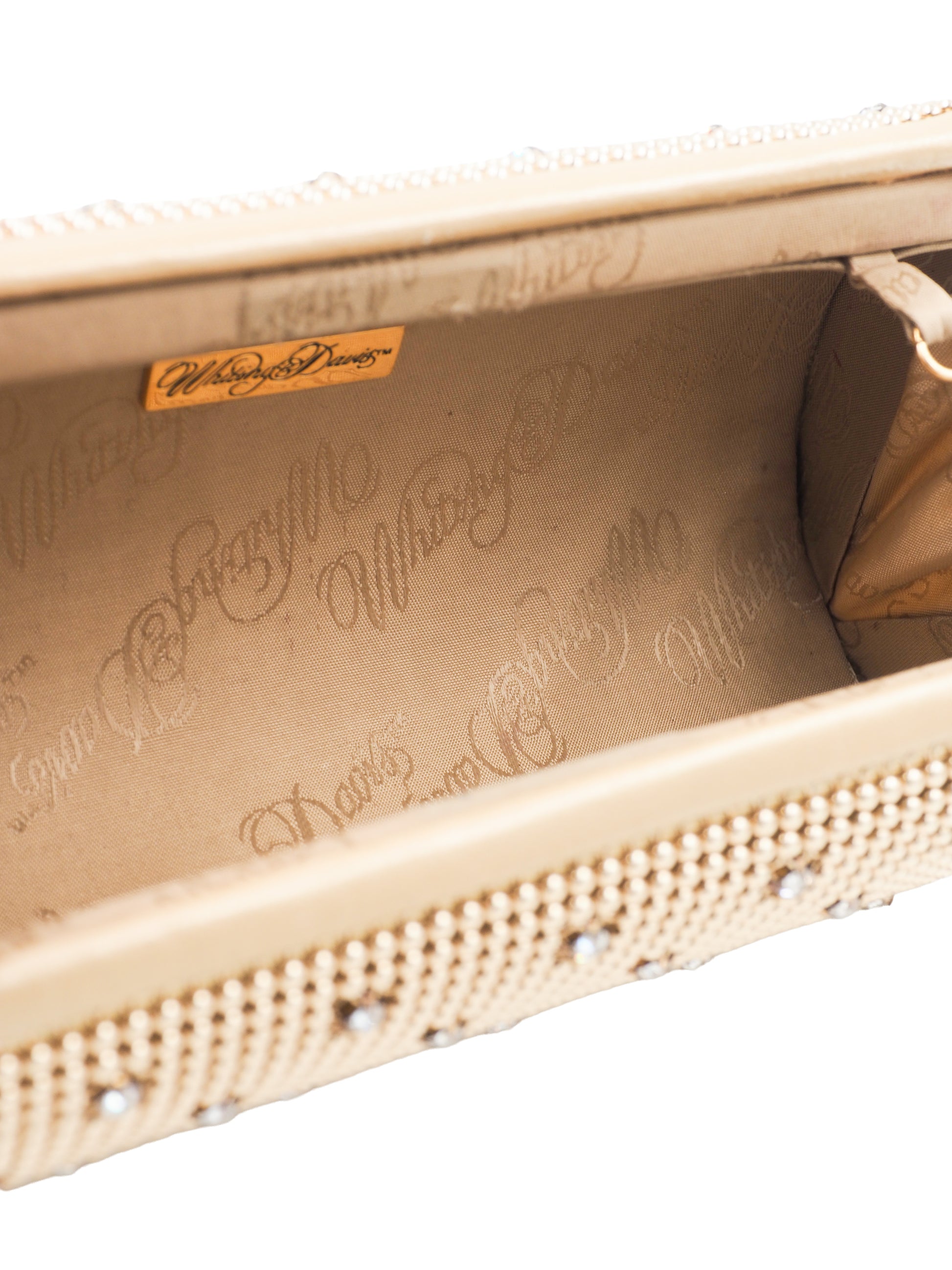 A whiting and davis gold-toned metallic clutch bag covered in a dense mesh of small rhinestones, decorated with a grid pattern of silver crystal studs