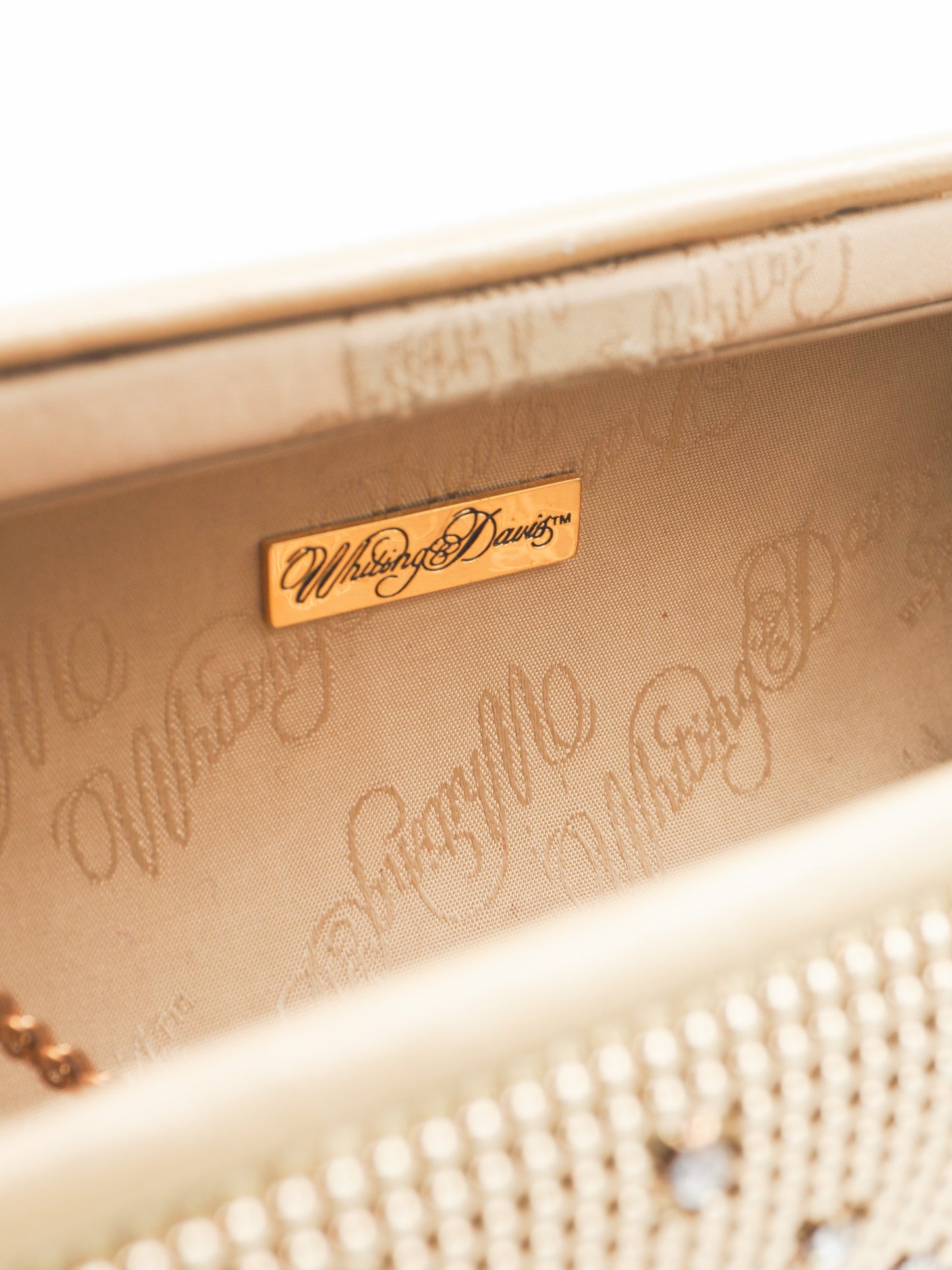 A whiting and davis gold-toned metallic clutch bag covered in a dense mesh of small rhinestones, decorated with a grid pattern of silver crystal studs