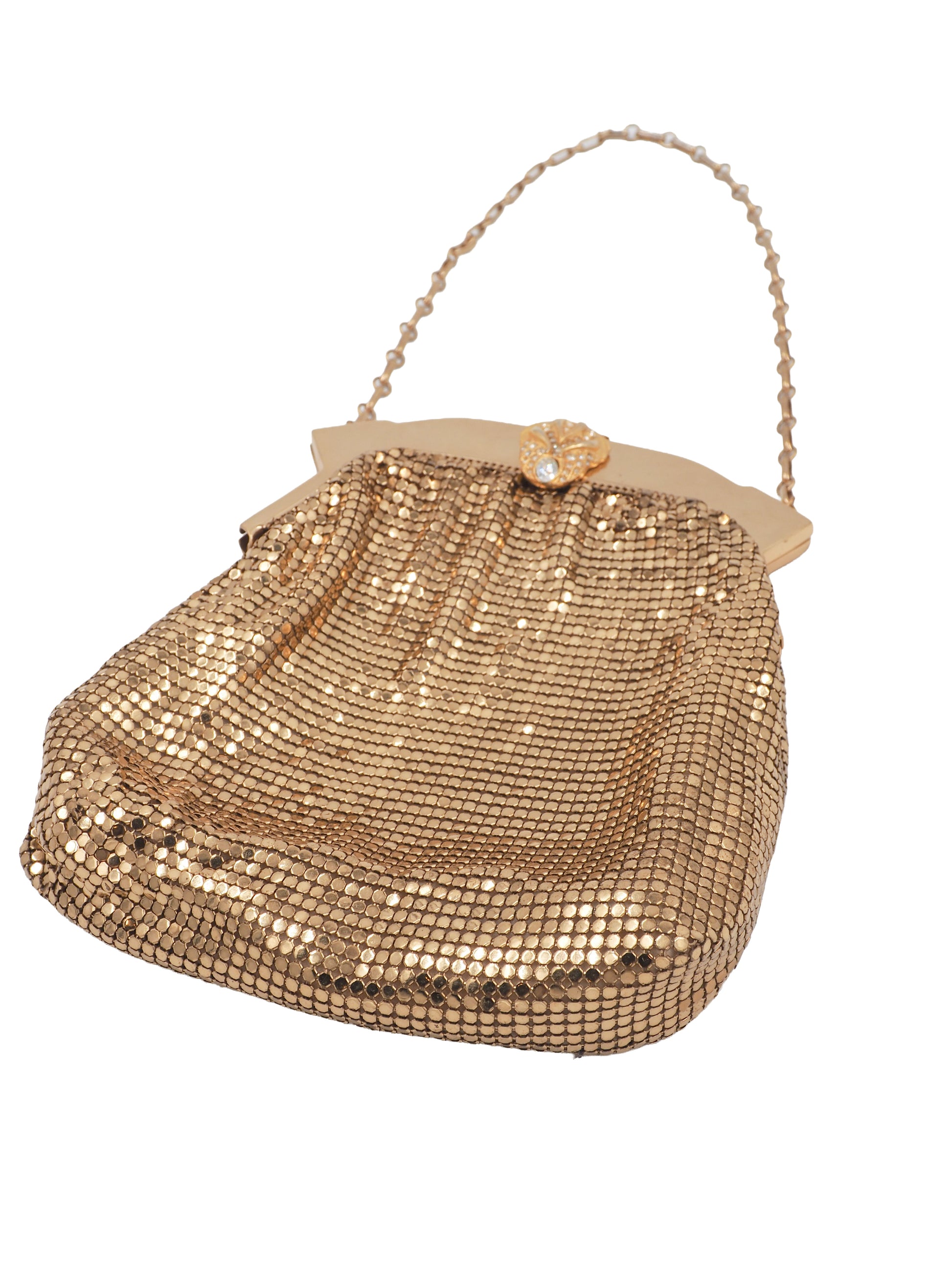 A whiting & Davis gold metallic mesh clutch handbag with a chain strap and a decorative gold clasp, shown on a plain white background.
